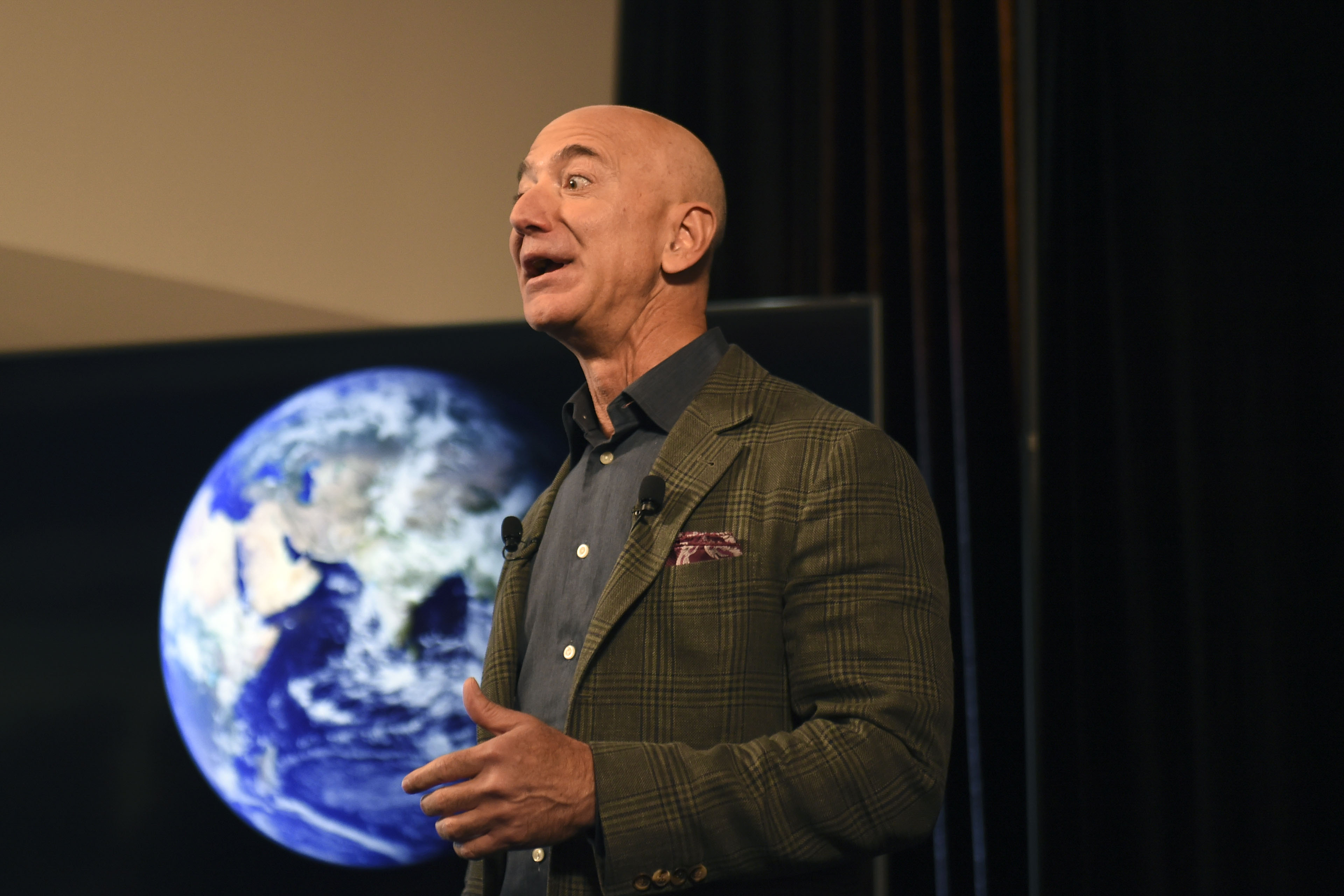 Jeff Bezos in front of a photo of Earth.