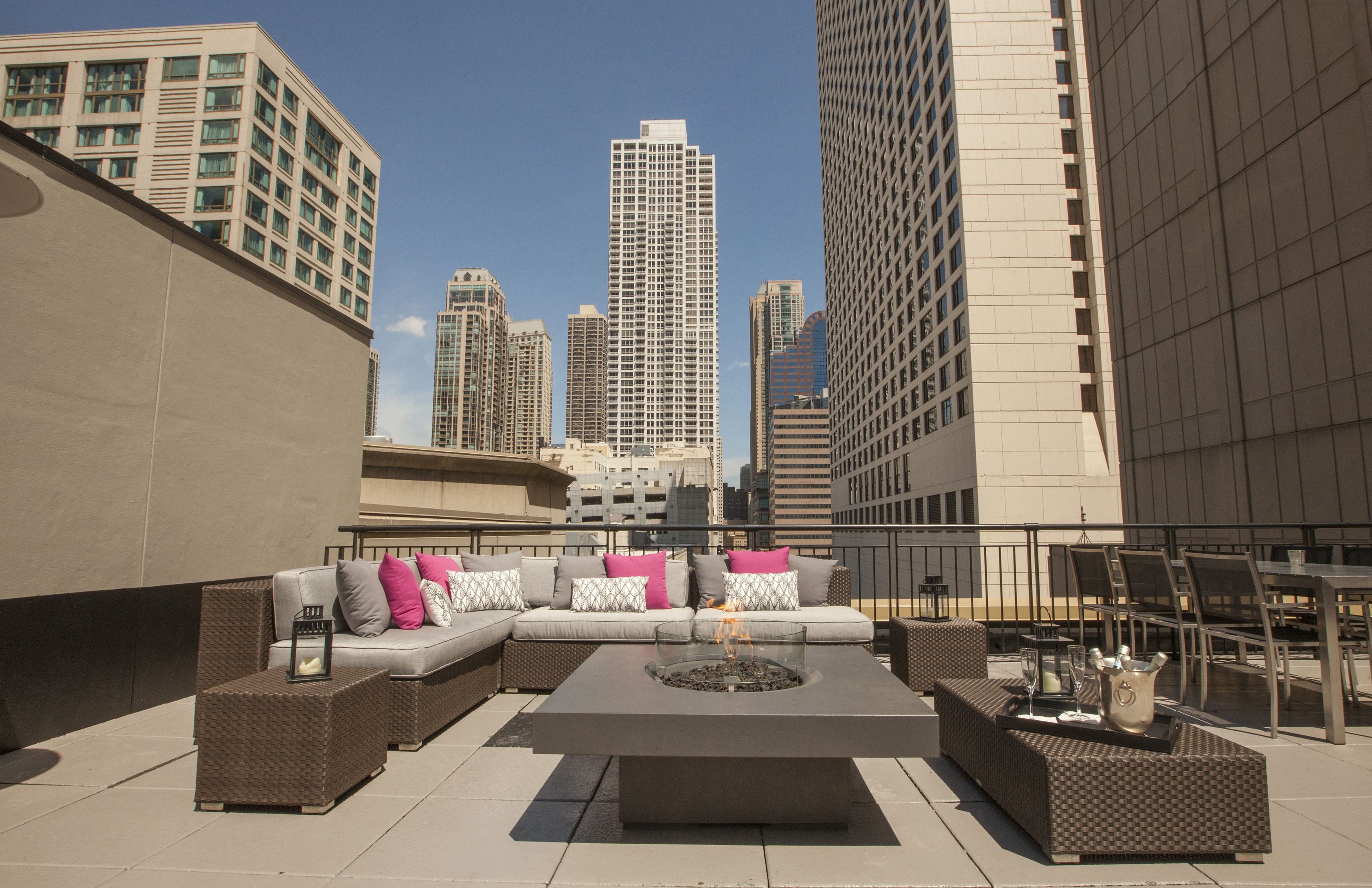 A rooftop lounge on top of a hotel, the Chicago skyline is in the background