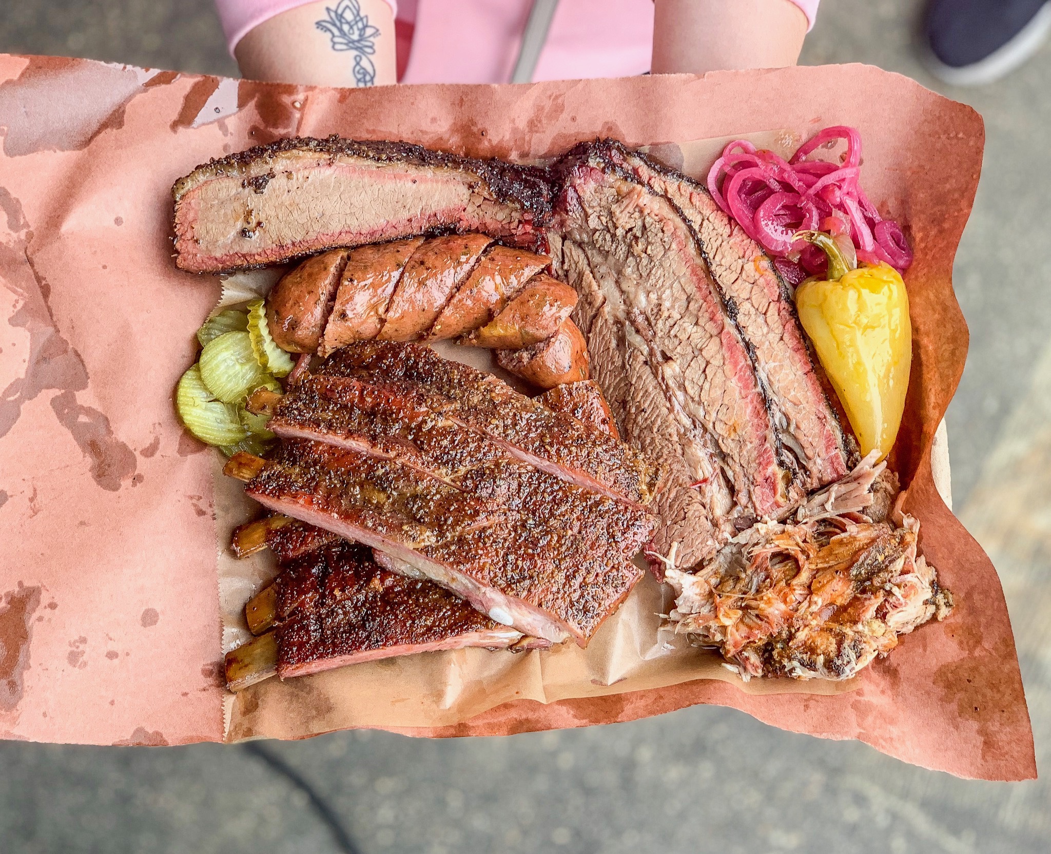 Moo’s craft barbecue sits on a pink paper tray.