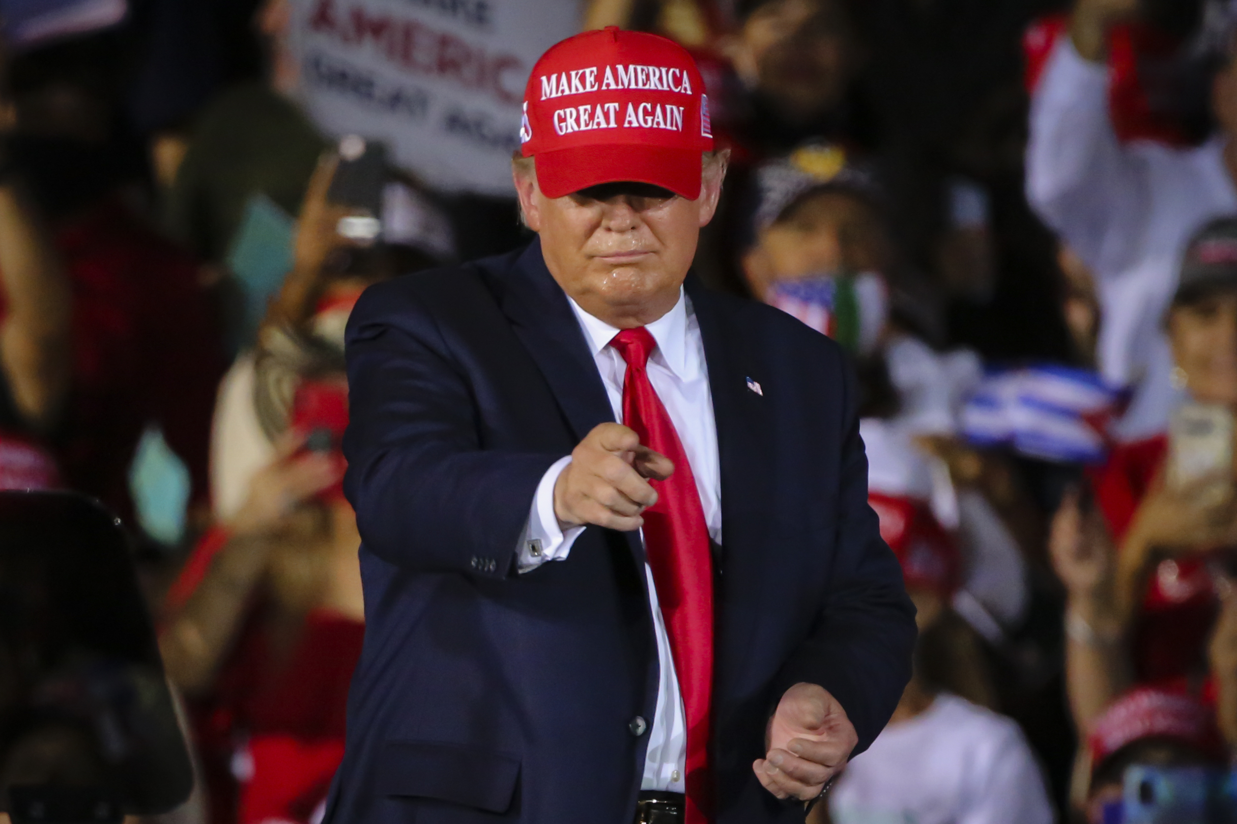 Donald Trump at a rally wearing a “Make America Great Again” hat.