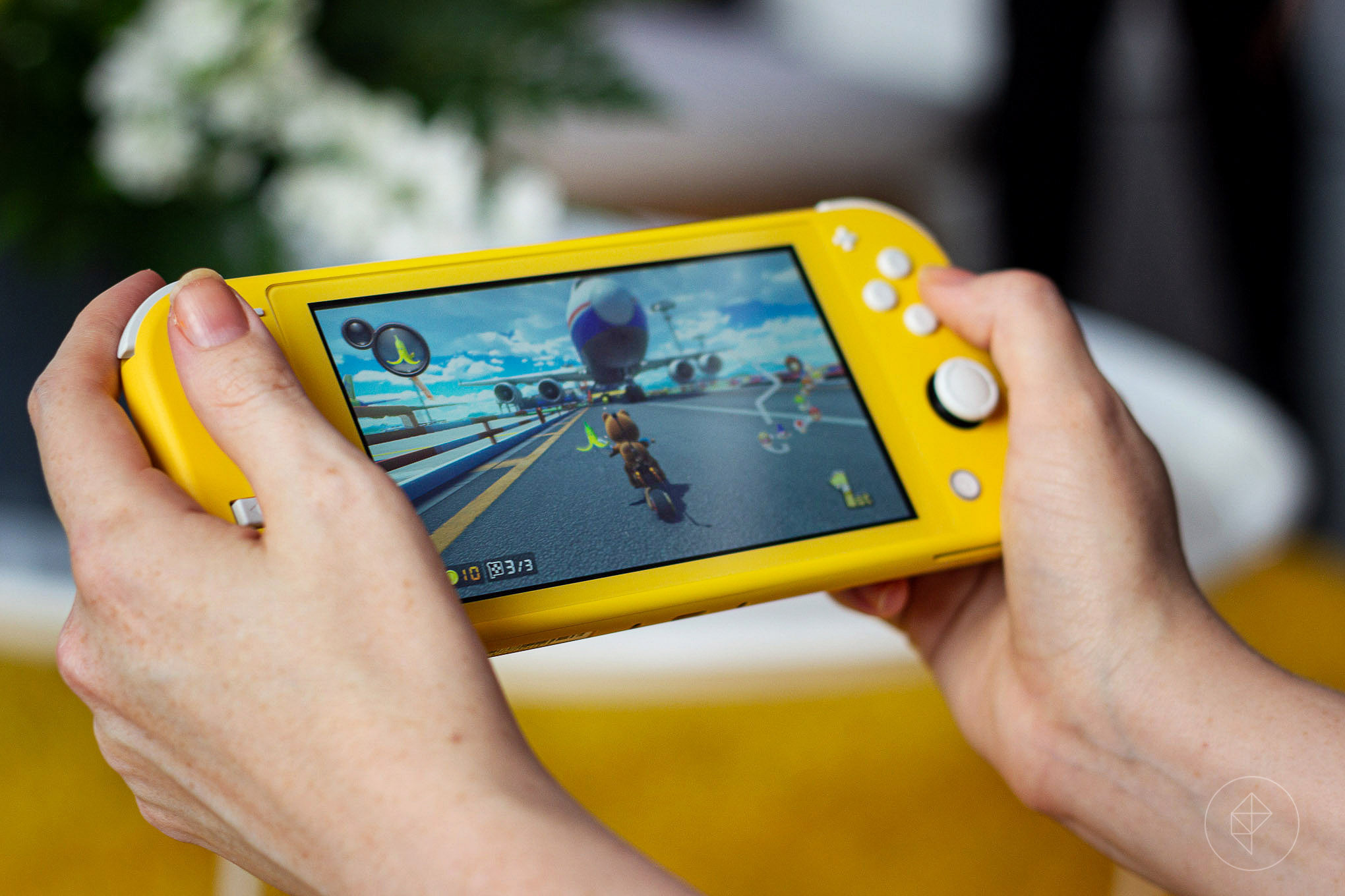 Photograph of a yellow Nintendo Switch Lite playing Mario Kart 8 Deluxe