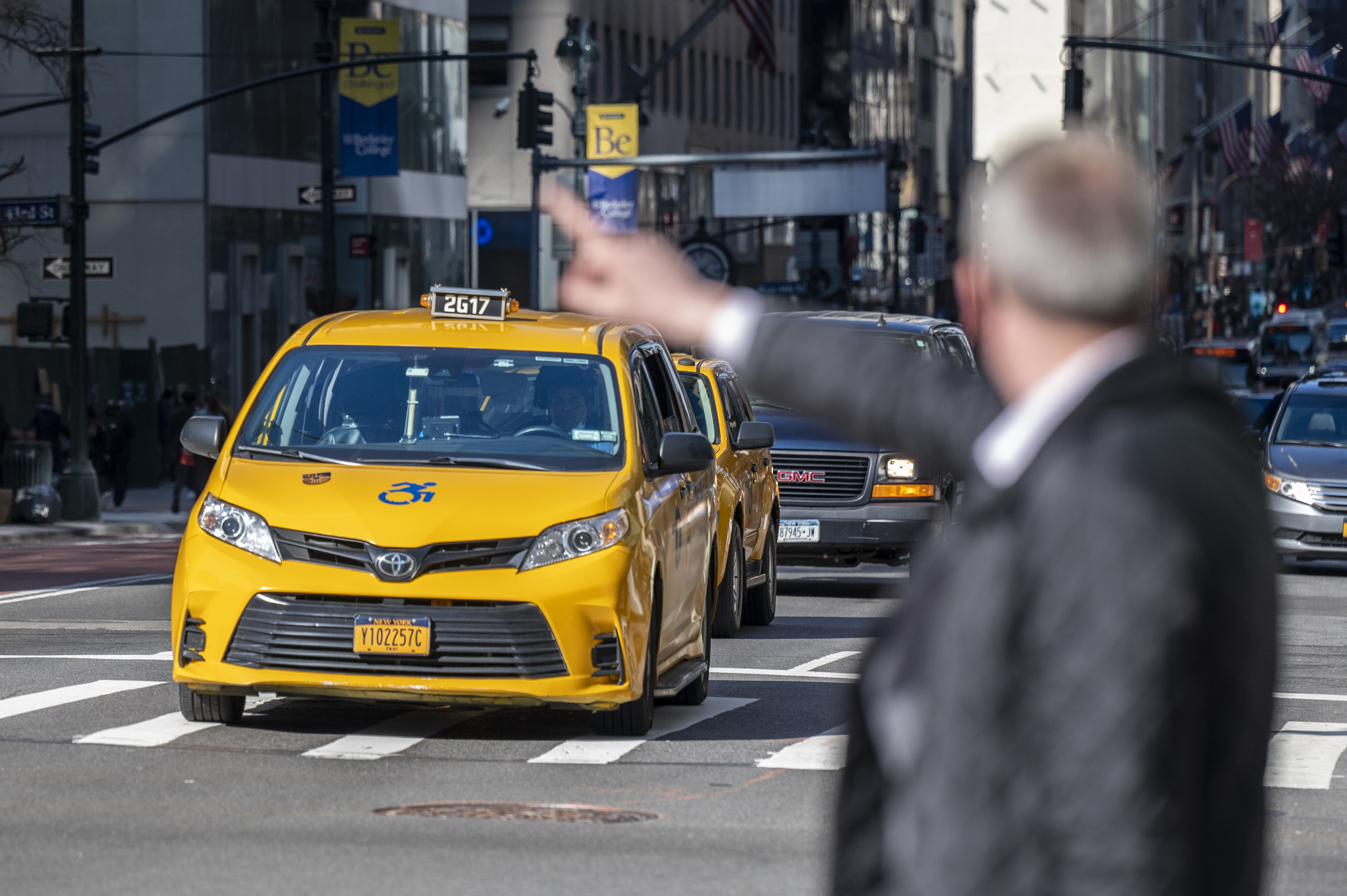A commuter hailing a cab at the intersection of 5th Ave and E 42 St.