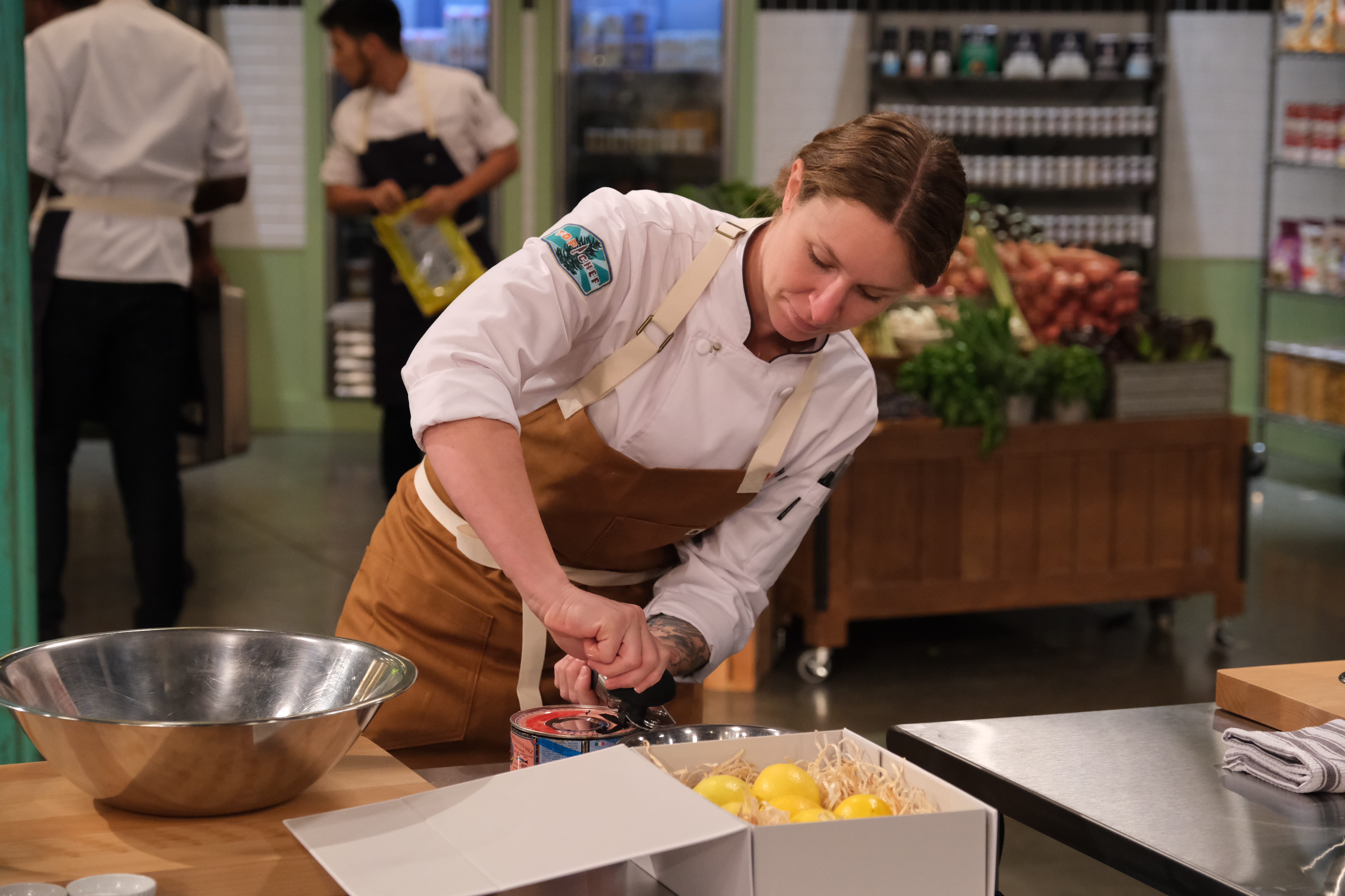 Sara Hauman leans over a lemon juicer during a challenge during the first episode of Top Chef season 18.
