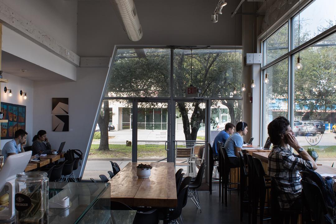 a window-heavy coffee shop with people sitting at counters