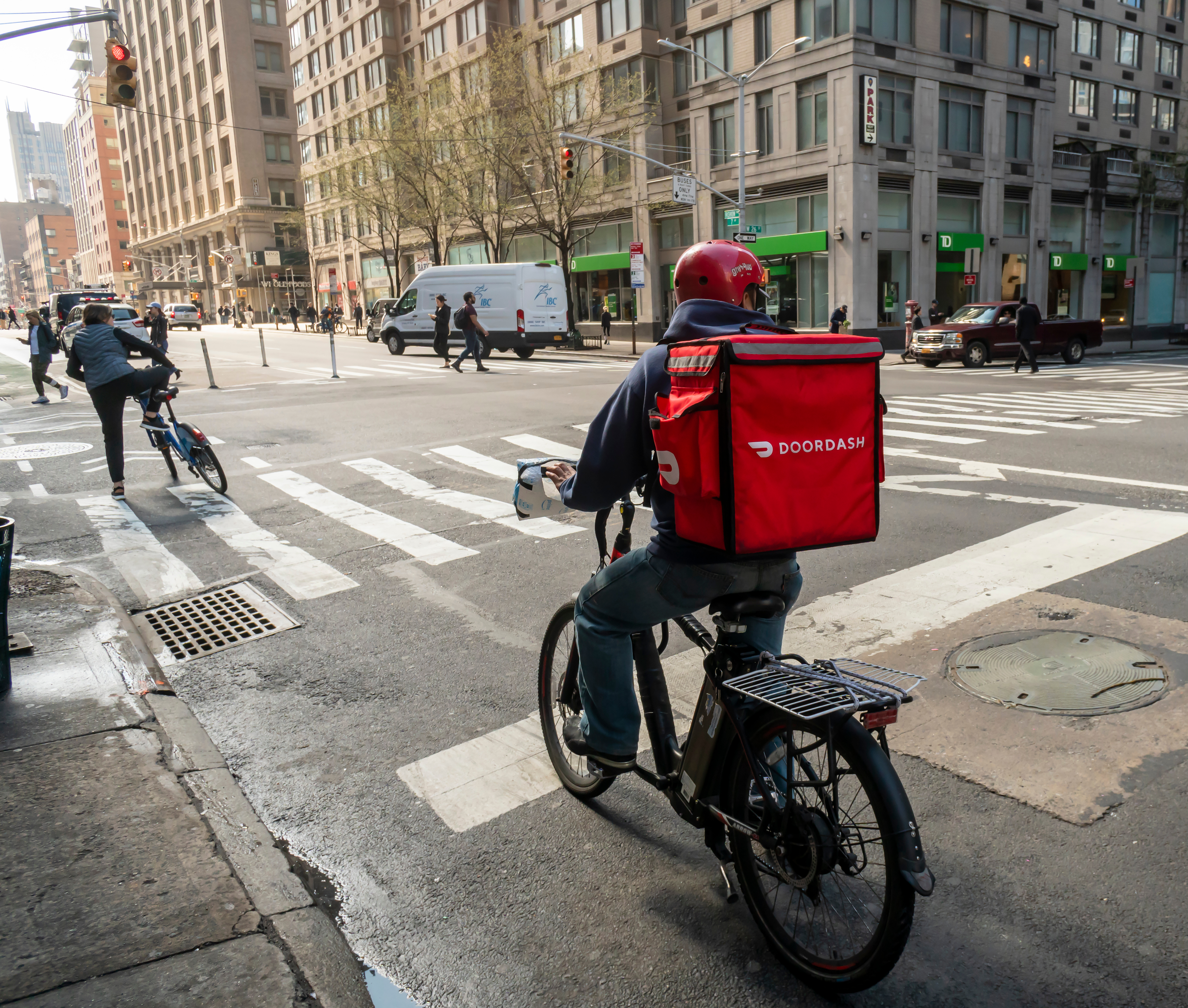 An image of a person riding a bike with a doordash red bag on the back