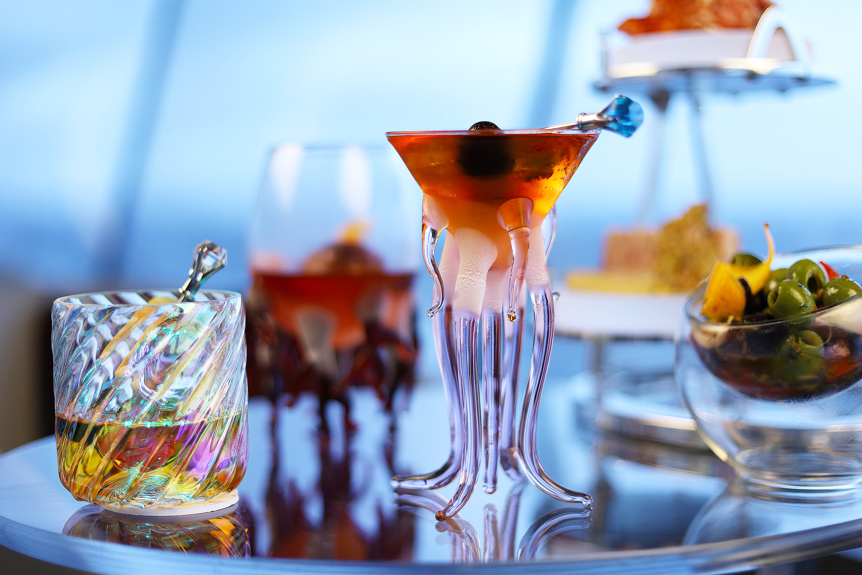 From the lounge at the top of the Space Needle, a view of several cocktails, including one served in a glass that evokes a tentacled sea creature