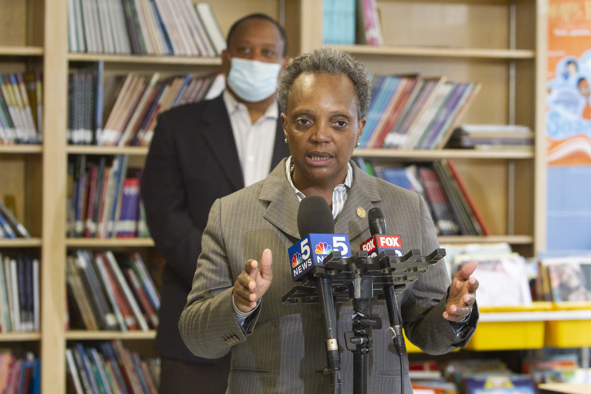 Mayor Lori Lightfoot talking into microphones at a press conference.