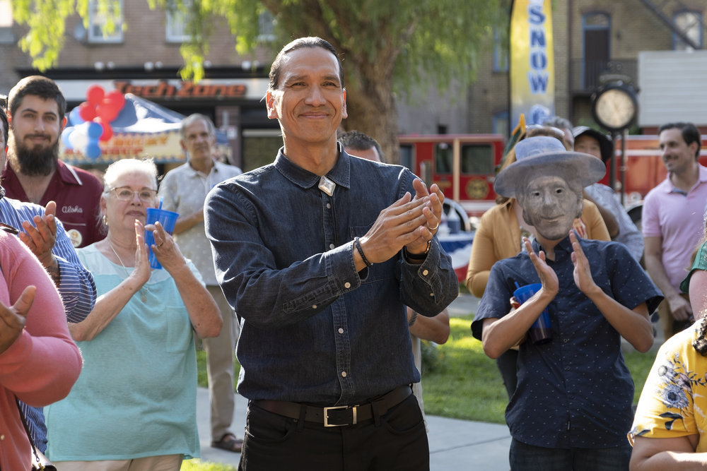 Terry Thomas, played by Michael Greyeyes, applauds at a park event in Peacock’s Rutherford Falls