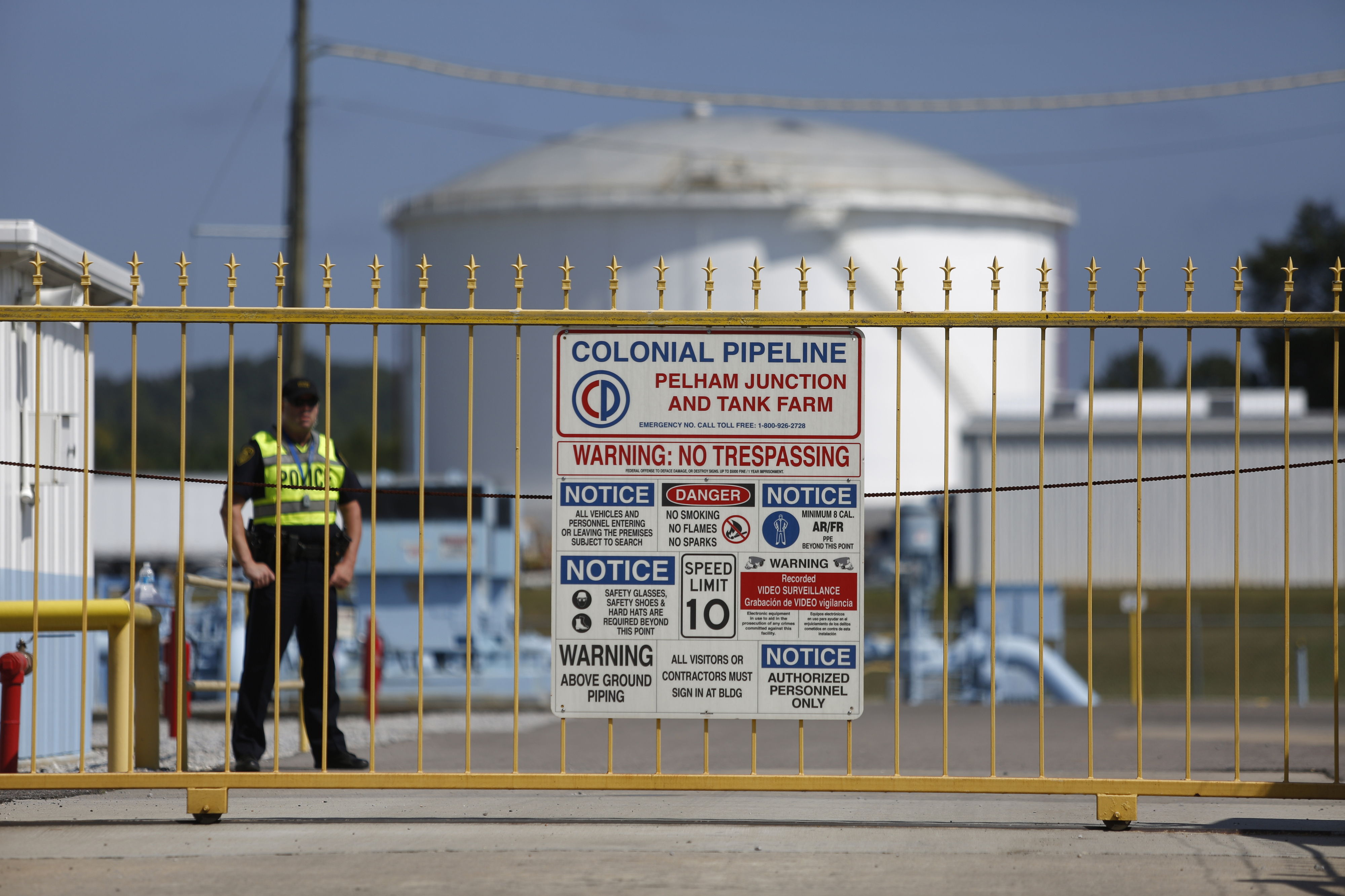 A police officer stands guard outside the Colonial Pipeline’s tank farm in Alabama.