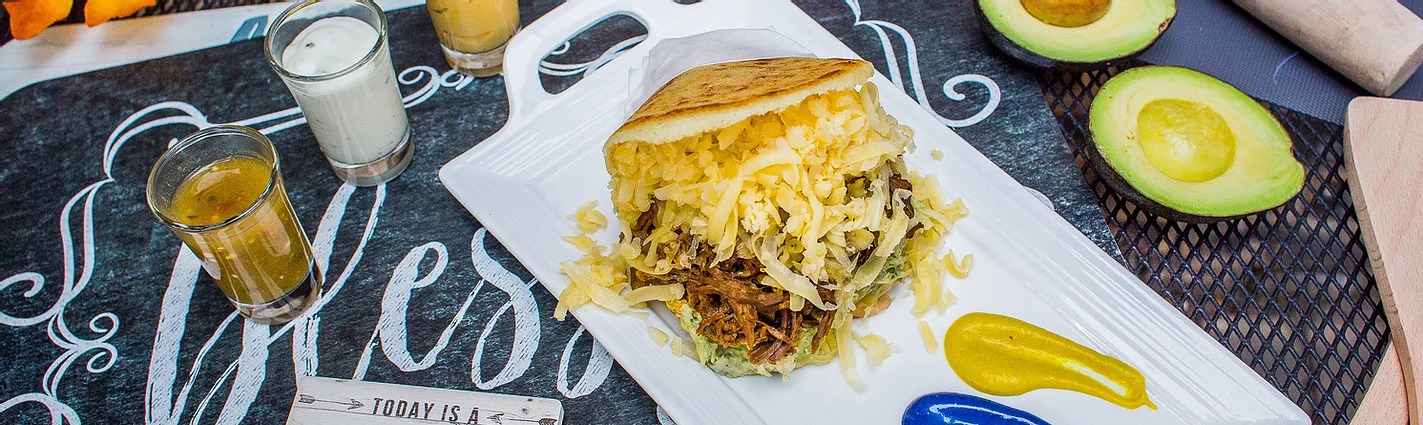 An arepa filed with meat, cheese, and veggies.