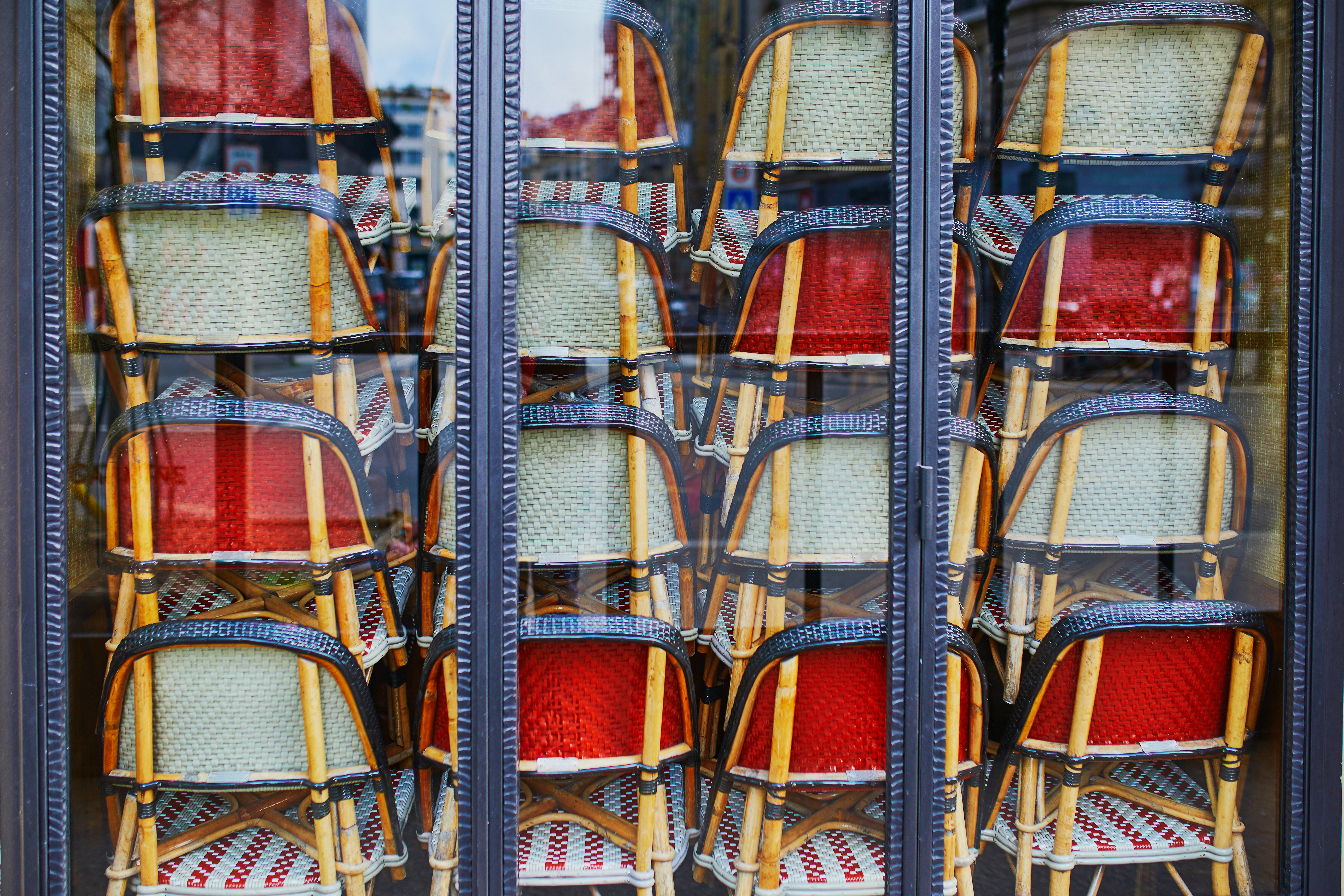 通过玻璃窗看到，堆叠的柳条椅掩盖了内心的观点。