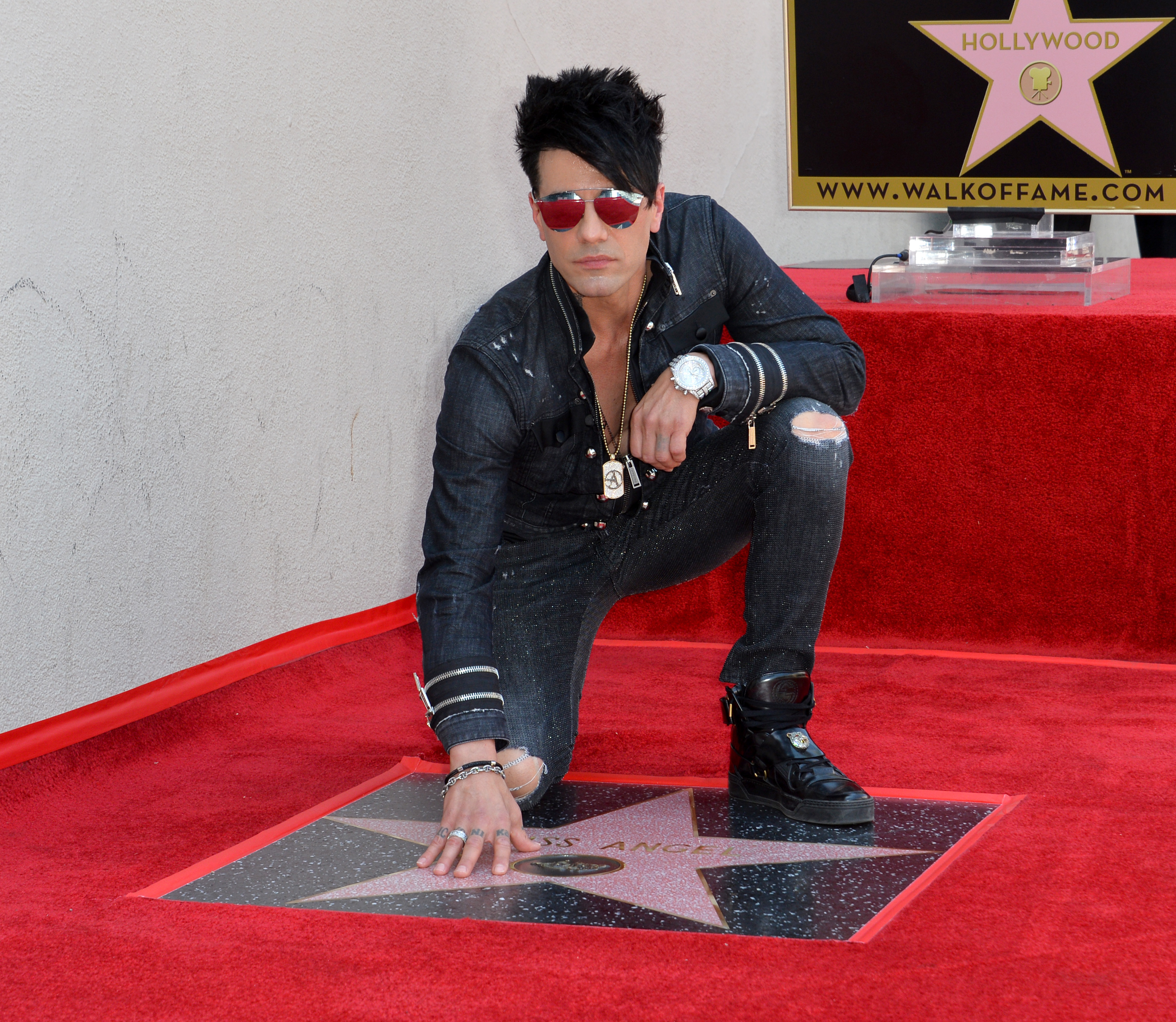Criss Angel kneels next to his star on the Hollywood Walk of Fame in 2017.