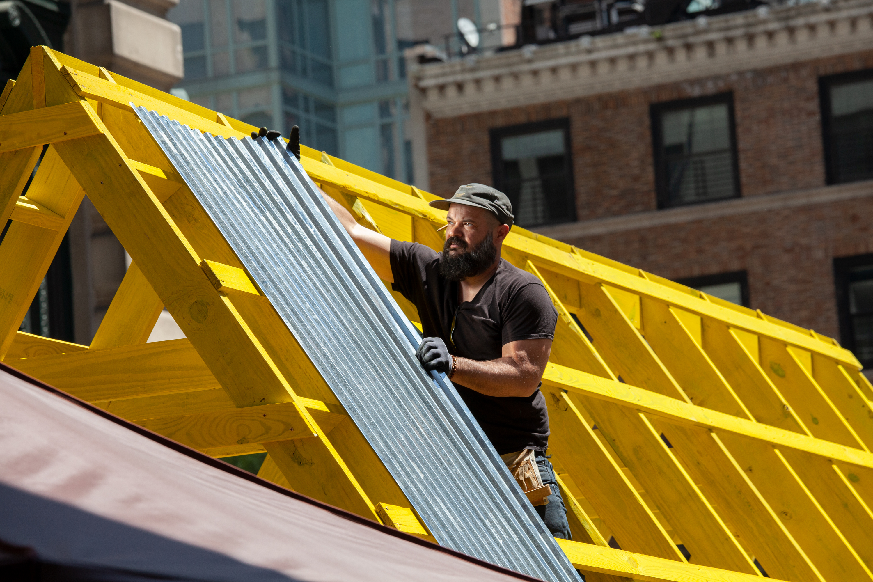 A worker helps build an outdoor eating area along 32nd Street in Koreatown, May 18, 2021.