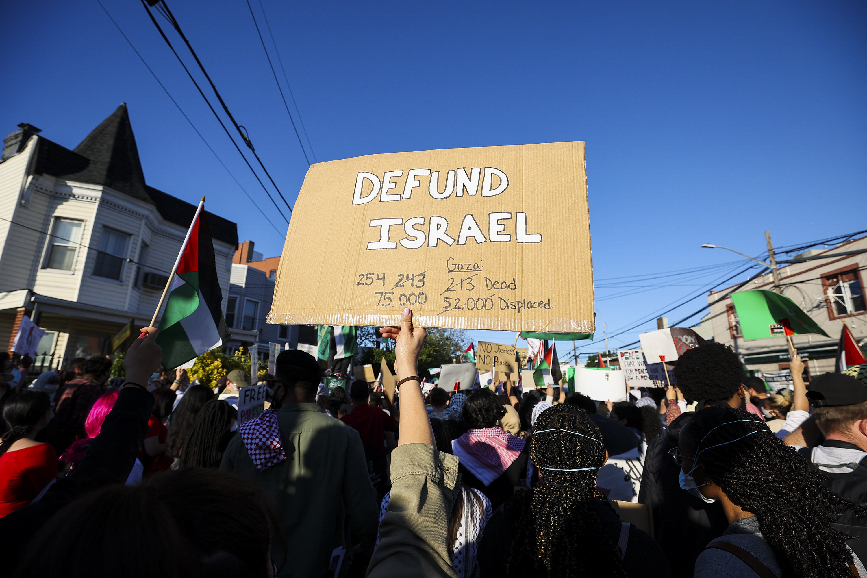 A protester holds up a sign that reads, “Defund Israel.”