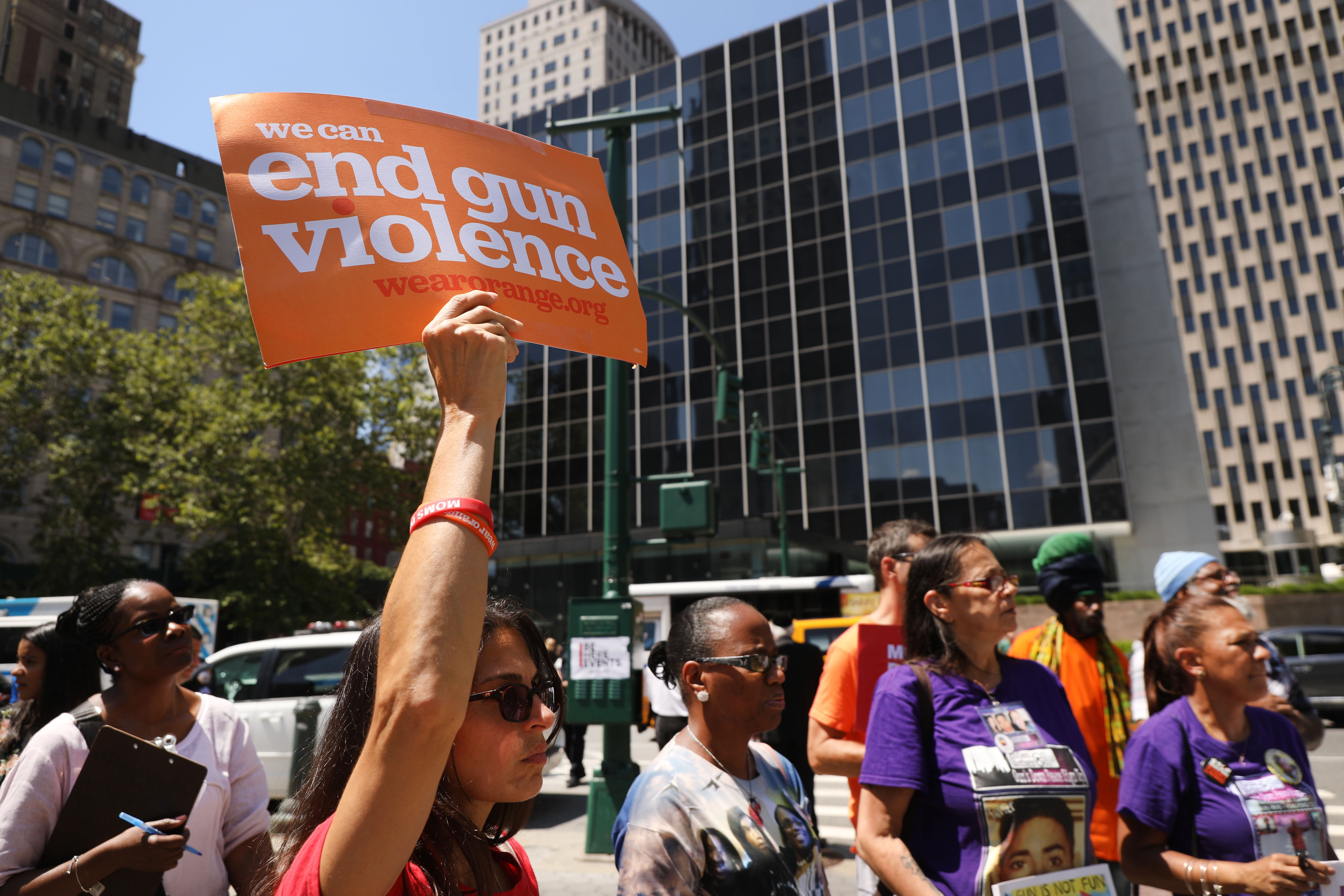 A person at a protest holds up a sign that reads, “End gun violence.”
