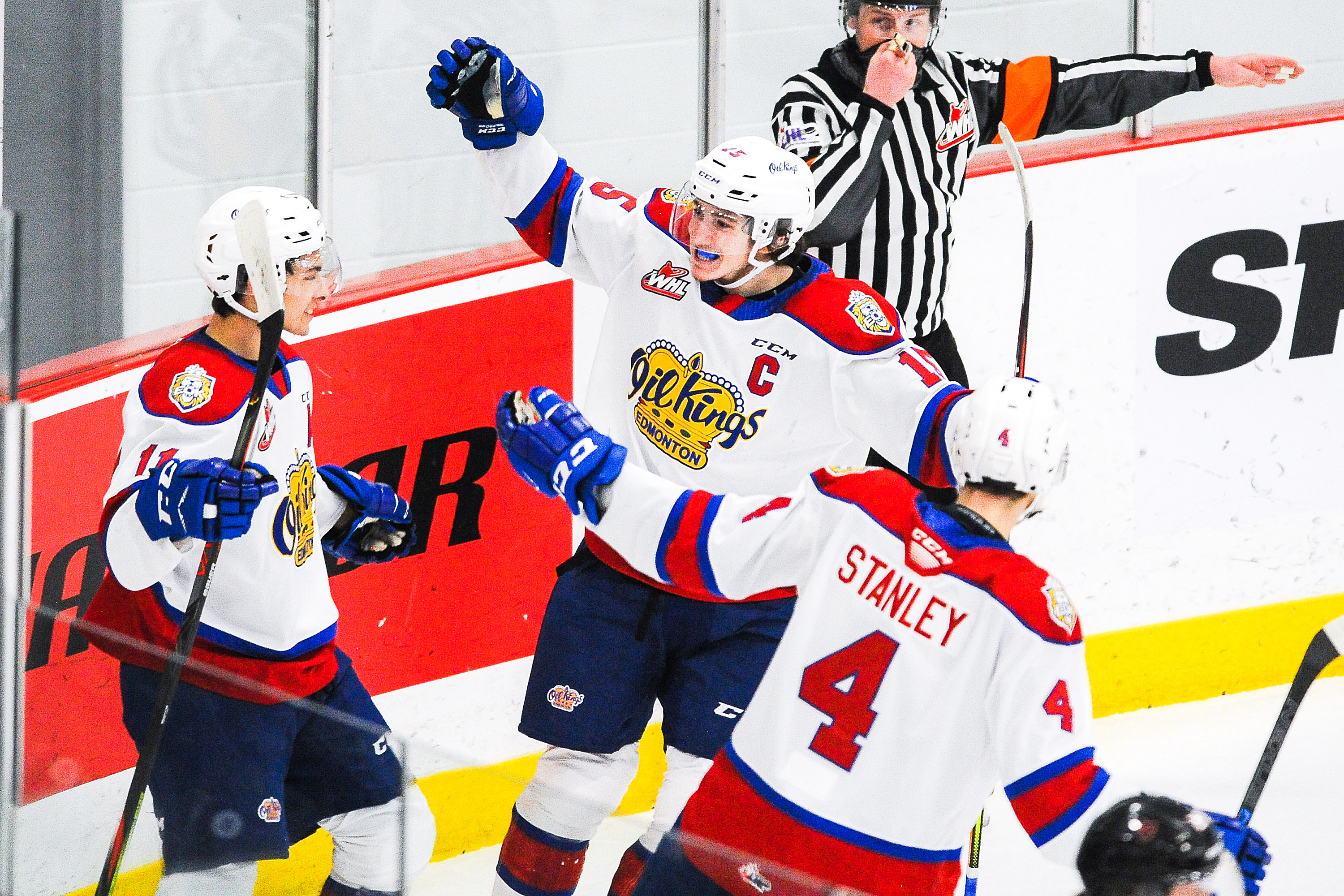 Dylan Guenther #11 (L) of the Edmonton Oil Kings celebrates with his teammates Scott Atkinson #15 (C) and Ross Stanley #4 (R) after scoring against the Calgary Hitmen during a WHL game at Seven Chiefs Sportsplex on March 27, 2021 in Calgary, Alberta, Canada.