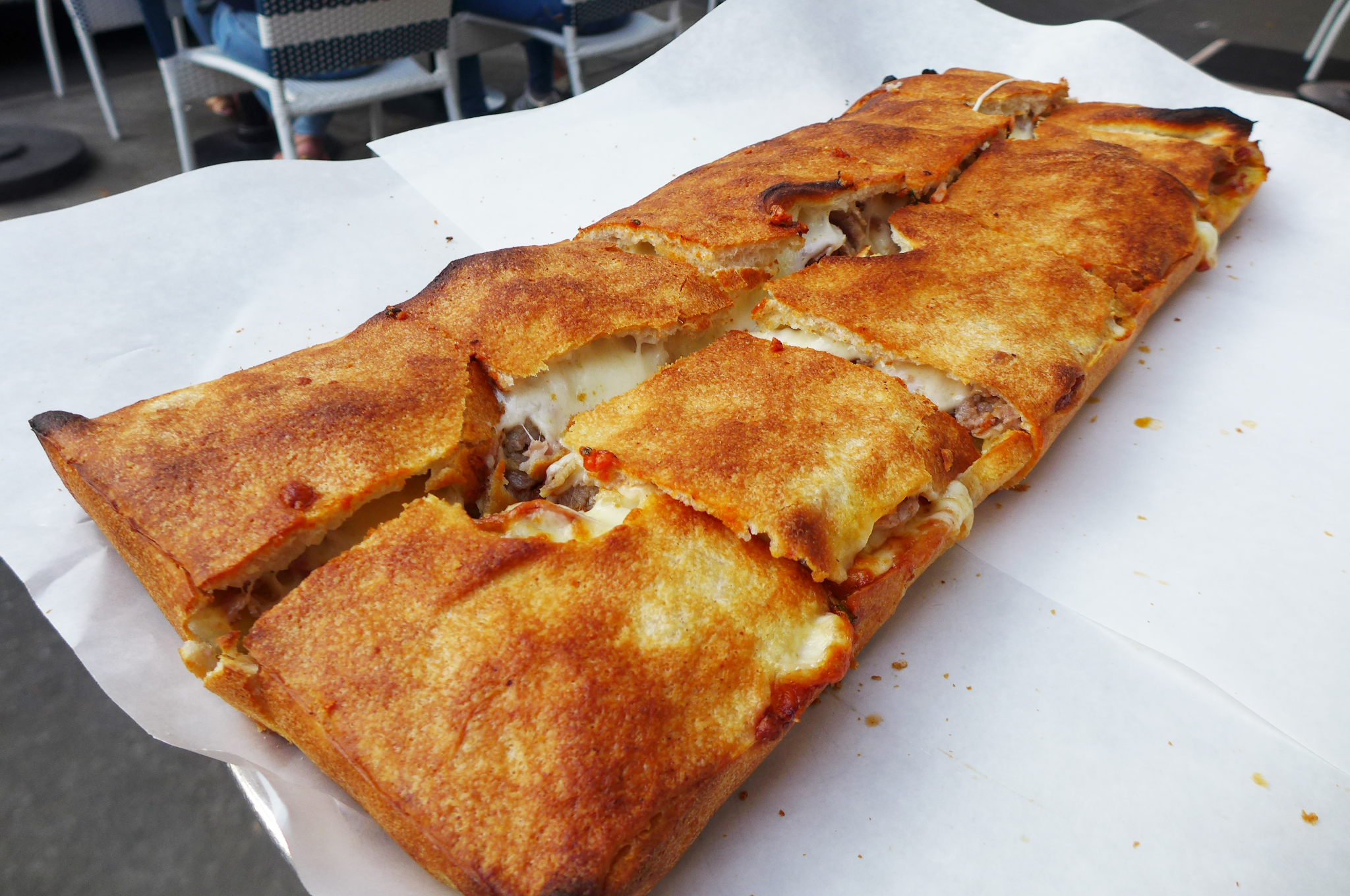 A rectangular pizza with a browned top crust.
