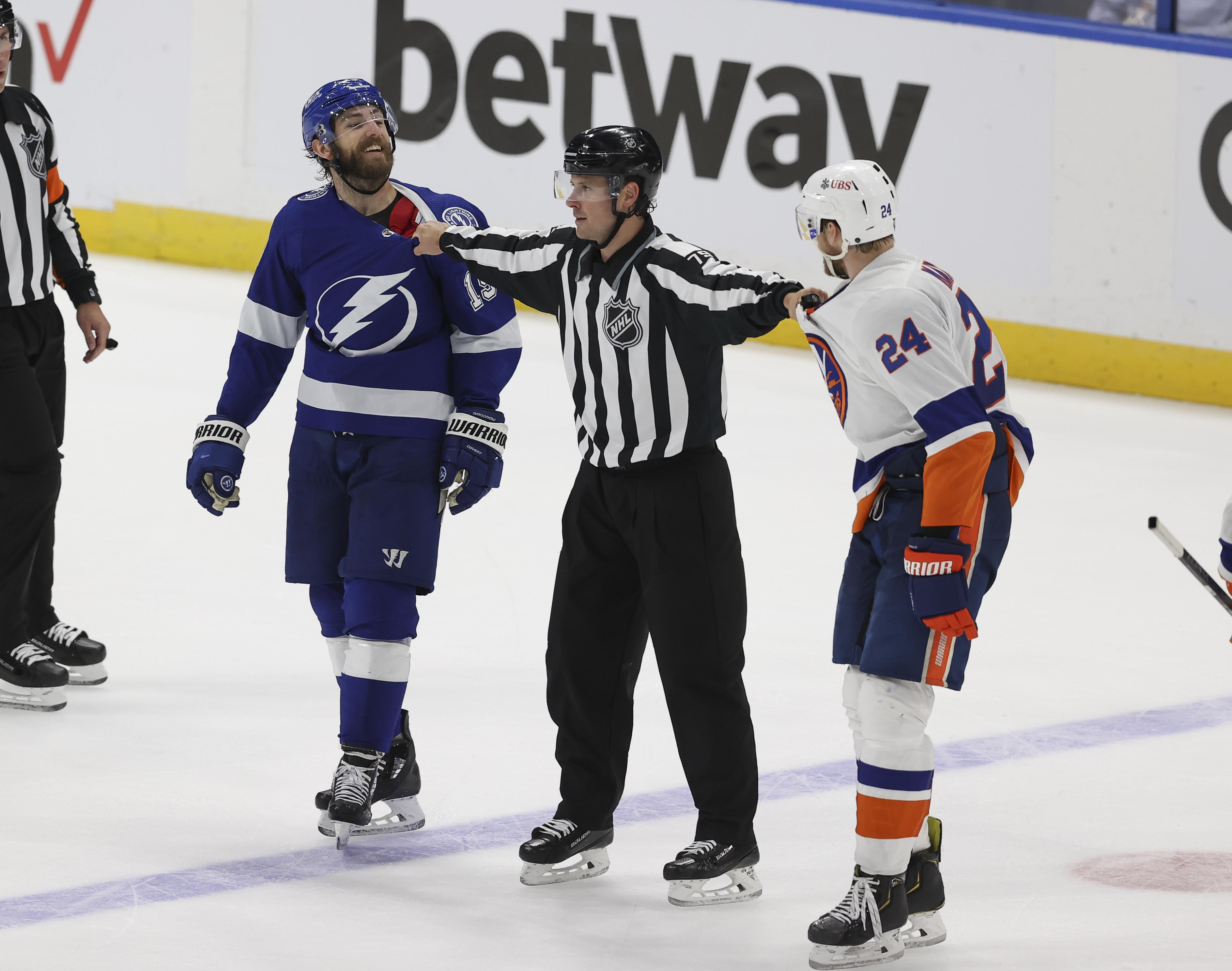 Tampa Bay Lightning right wing Barclay Goodrow (19) is separated from New York Islanders defenseman Scott Mayfield (24) by linesman Kiel Murchison (79) in the third period of Game 5 of the Stanley Cup Playoffs Semifinals between the New York Islanders and Tampa Bay Lightning on June 21, 2021 at Amalie Arena in Tampa, FL.