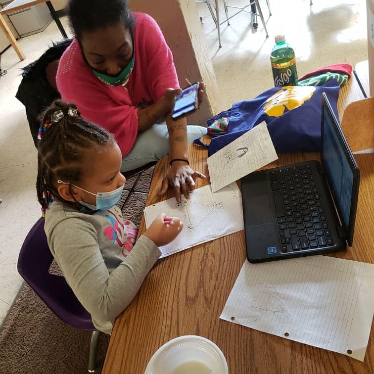 A Future Ties worker helps a student with her homework.