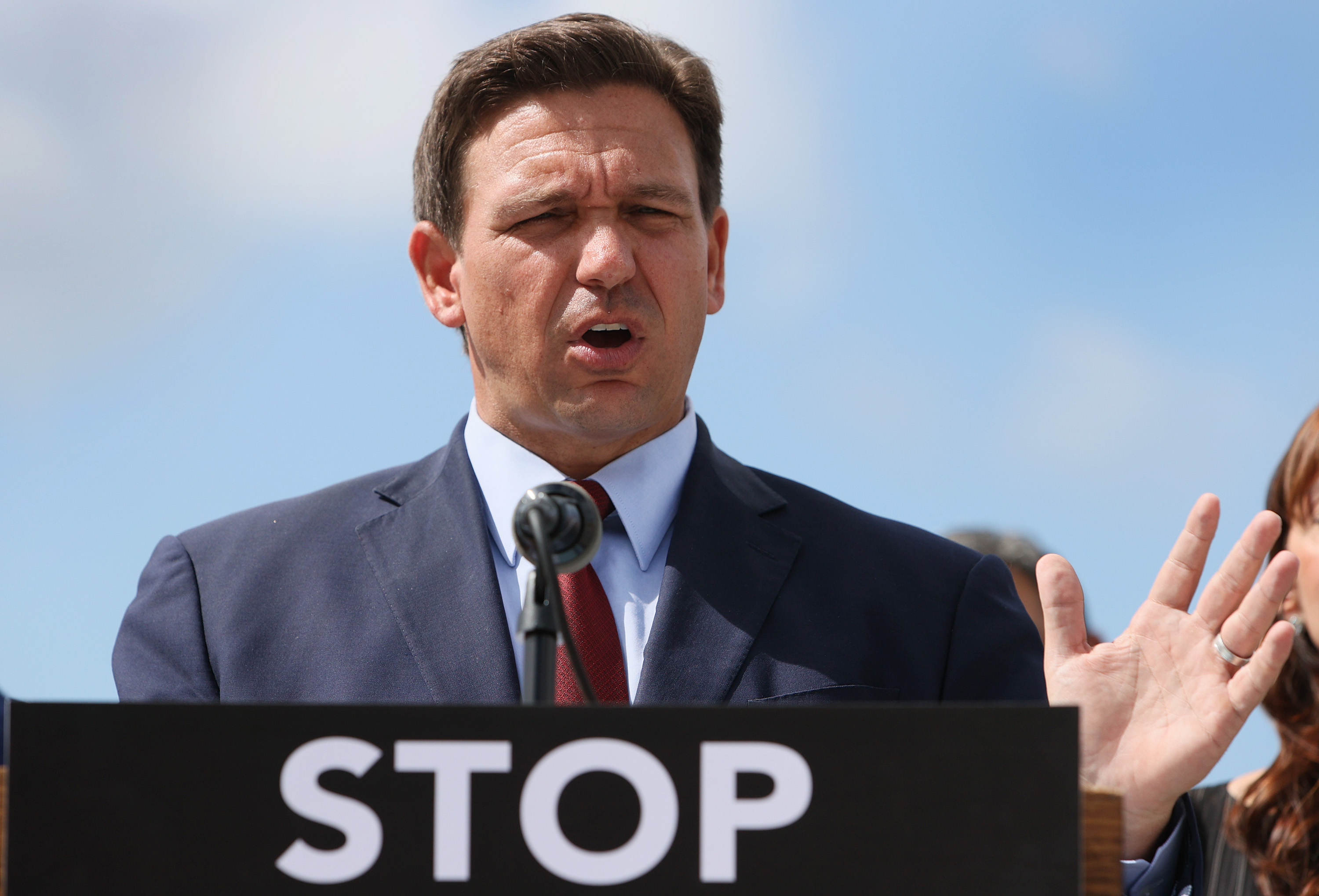 Florida Gov. Ron DeSantis speaks during a press conference held at the Florida National Guard Robert A. Ballard Armory on June 7, 2021 in Miami, Florida. The word “stop” is visible on the lectern.