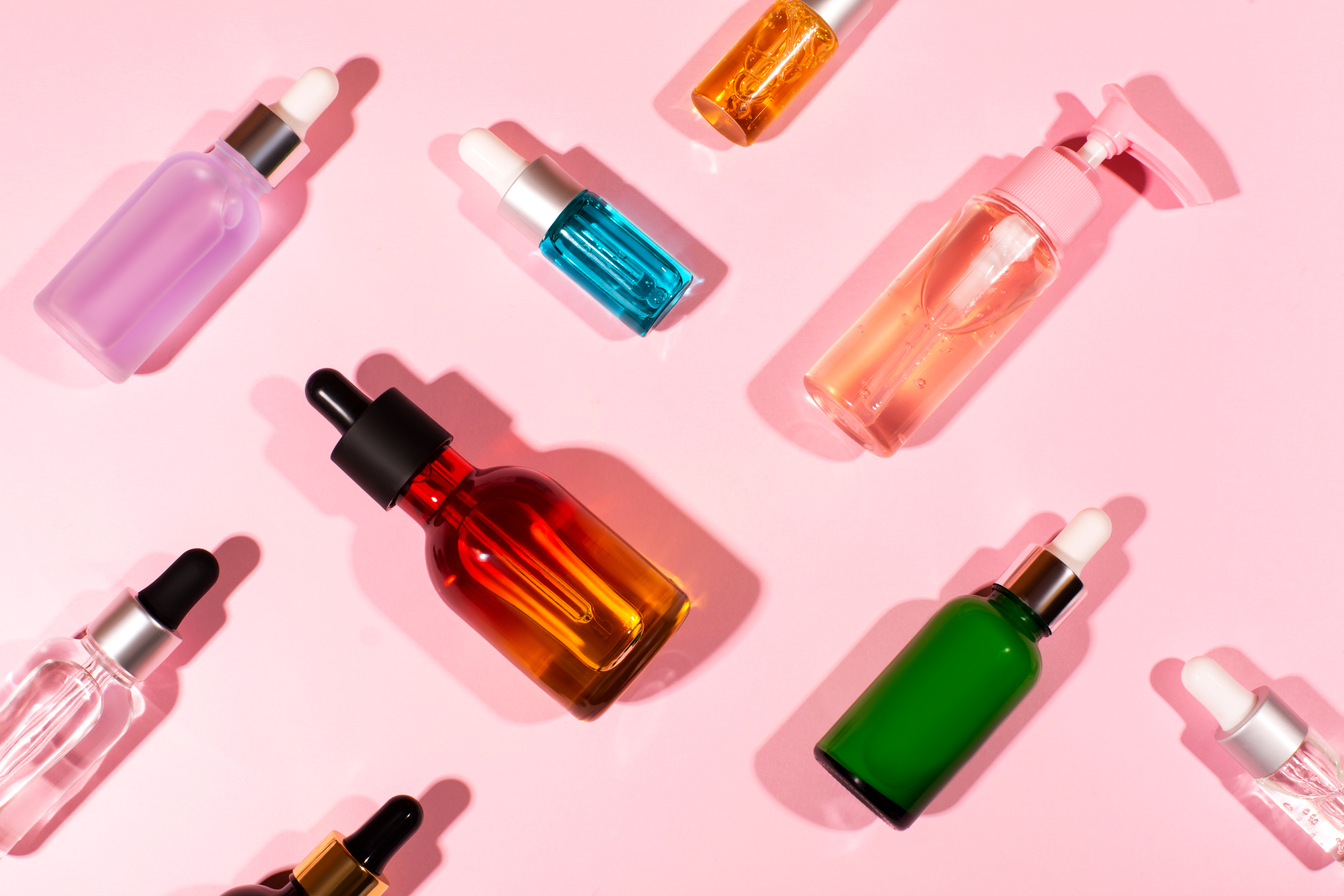 Colorful cosmetics bottles arranged on their sides in a diagonal grid.
