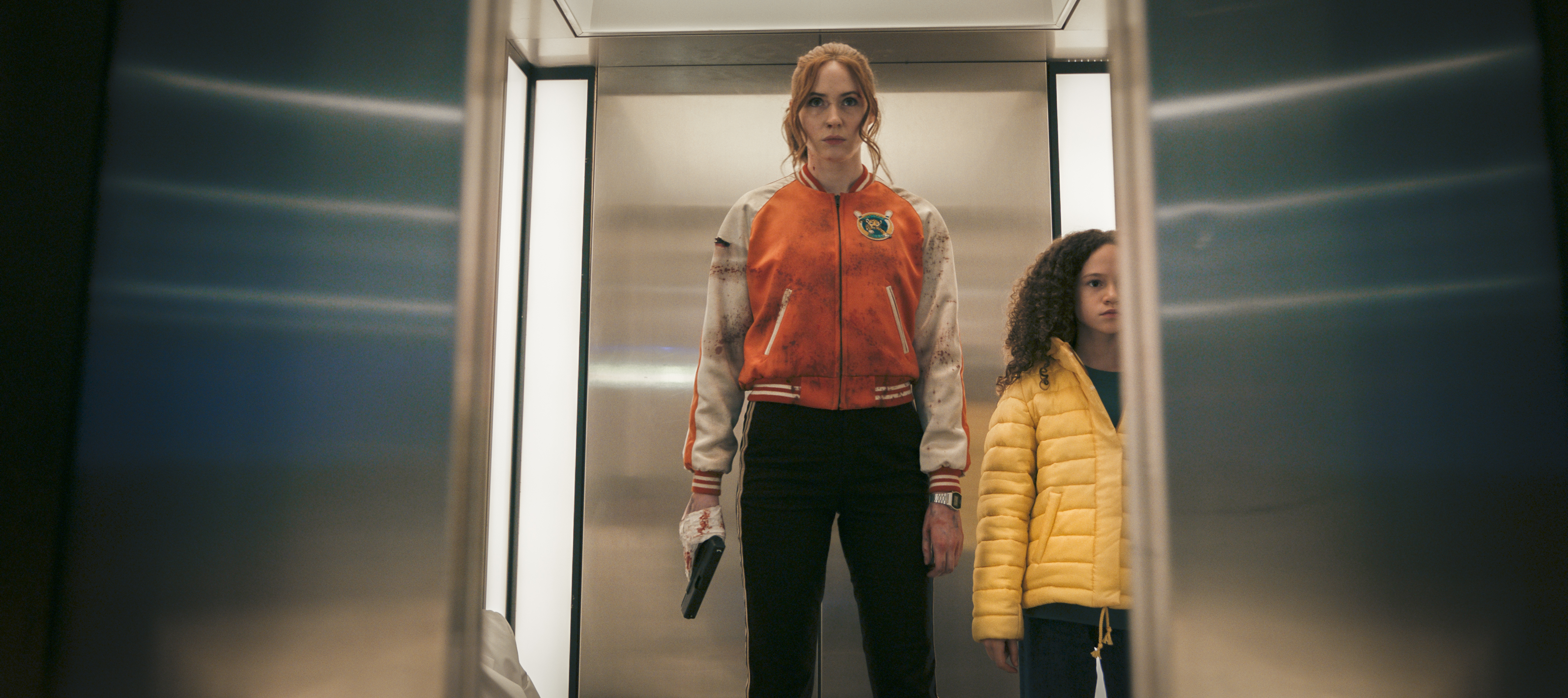 Karen Gillan as Sam and Chloe Coleman as Emily stand in an elevator in Gunpowder Milkshake