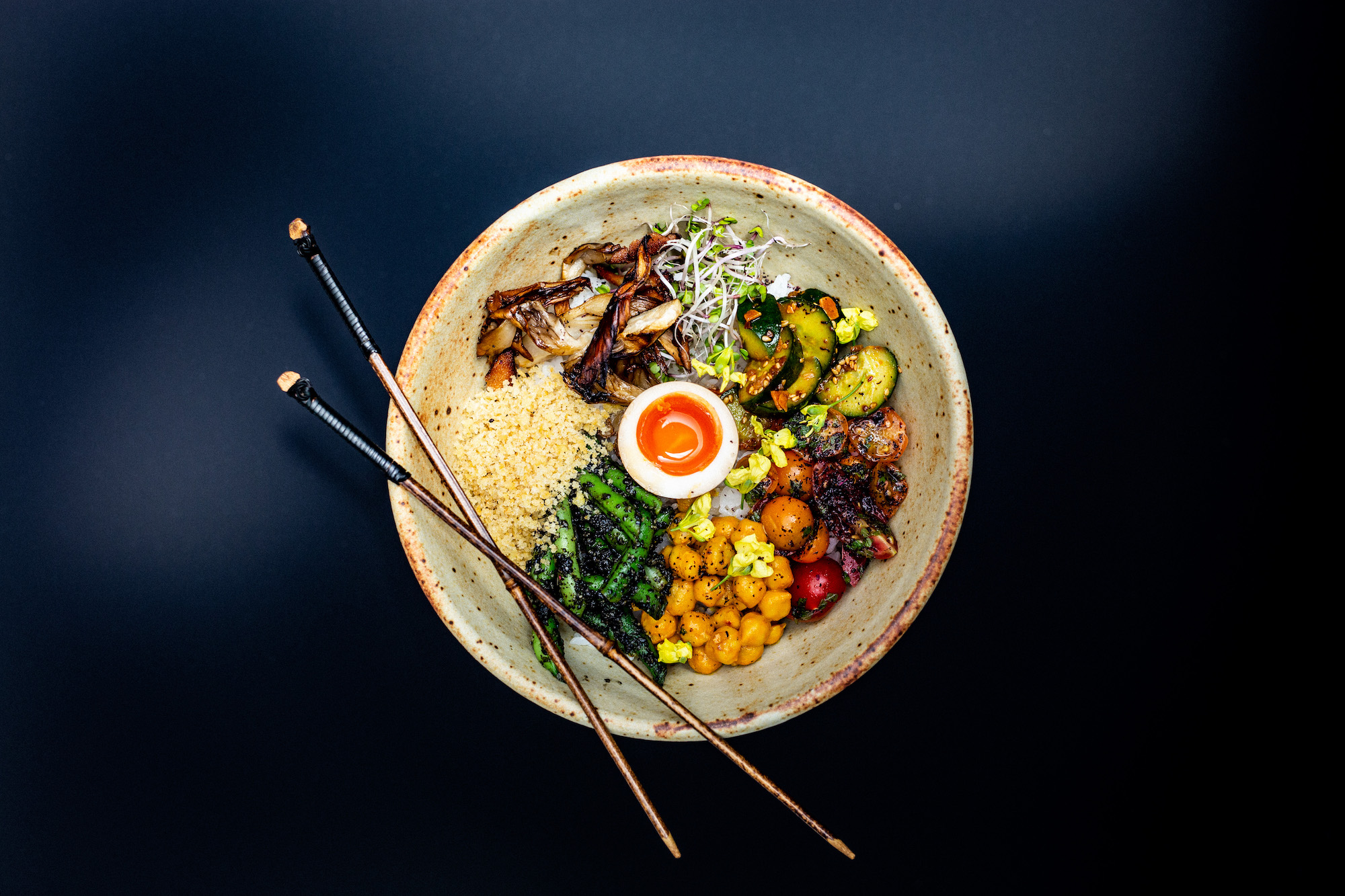 An overhead shot of a ceramic bowl with Japanese food inside.