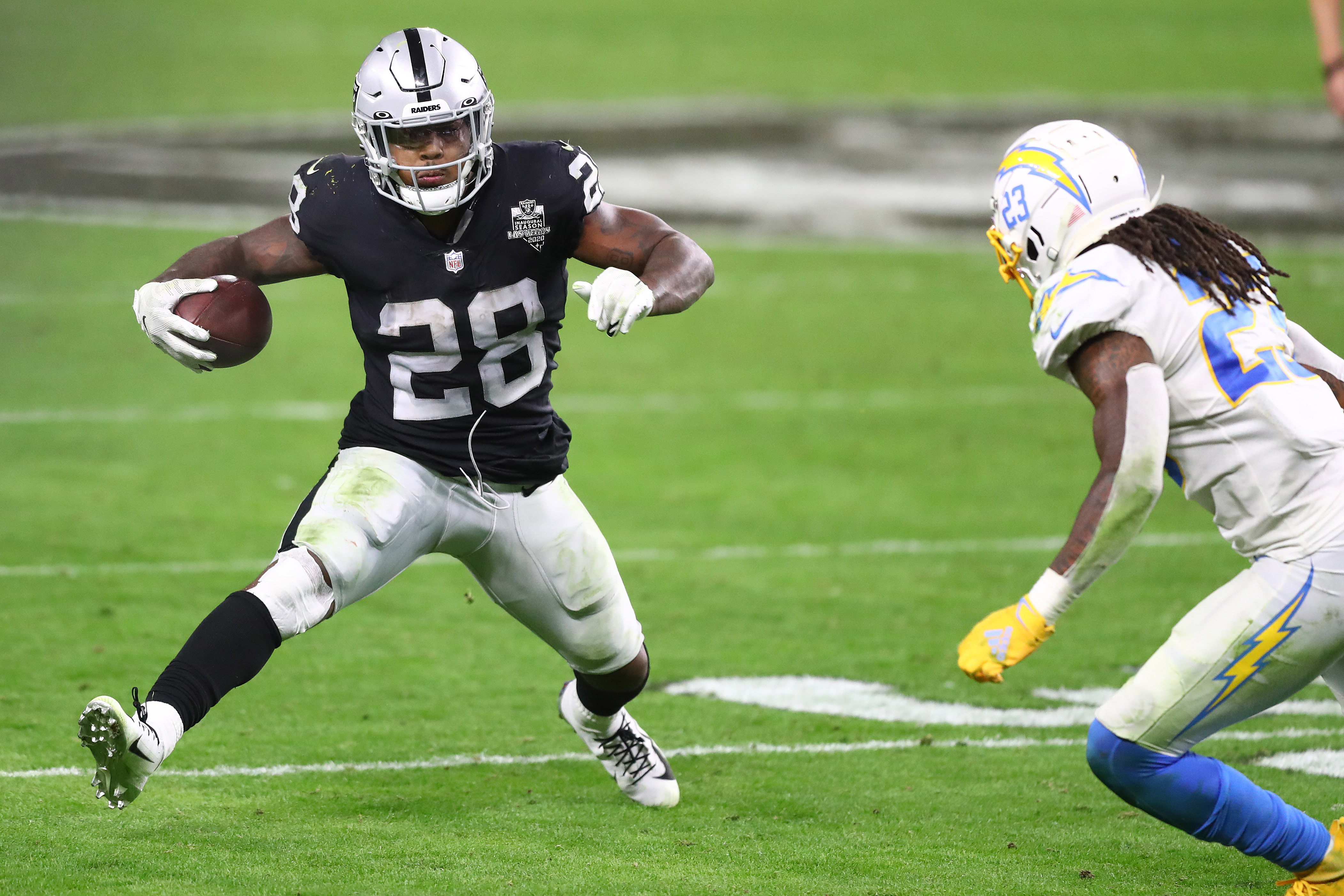 Raiders running back Josh Jacobs runs the ball against Los Angeles Chargers strong safety Rayshawn Jenkins during overtime at Allegiant Stadium.