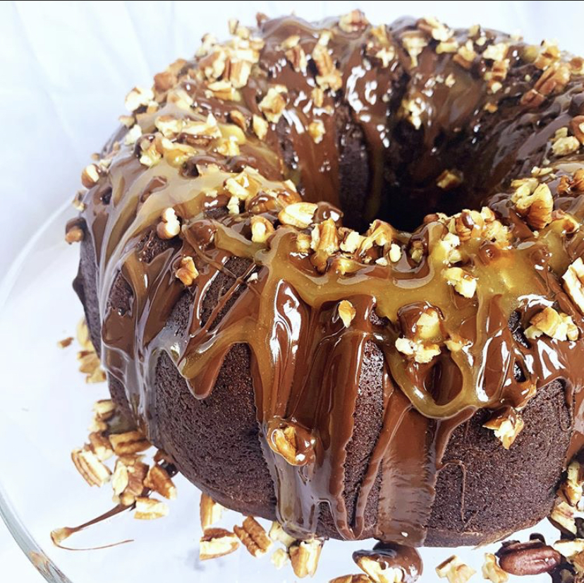 A chocolate pound cake drizzled with caramel and topped with nuts
