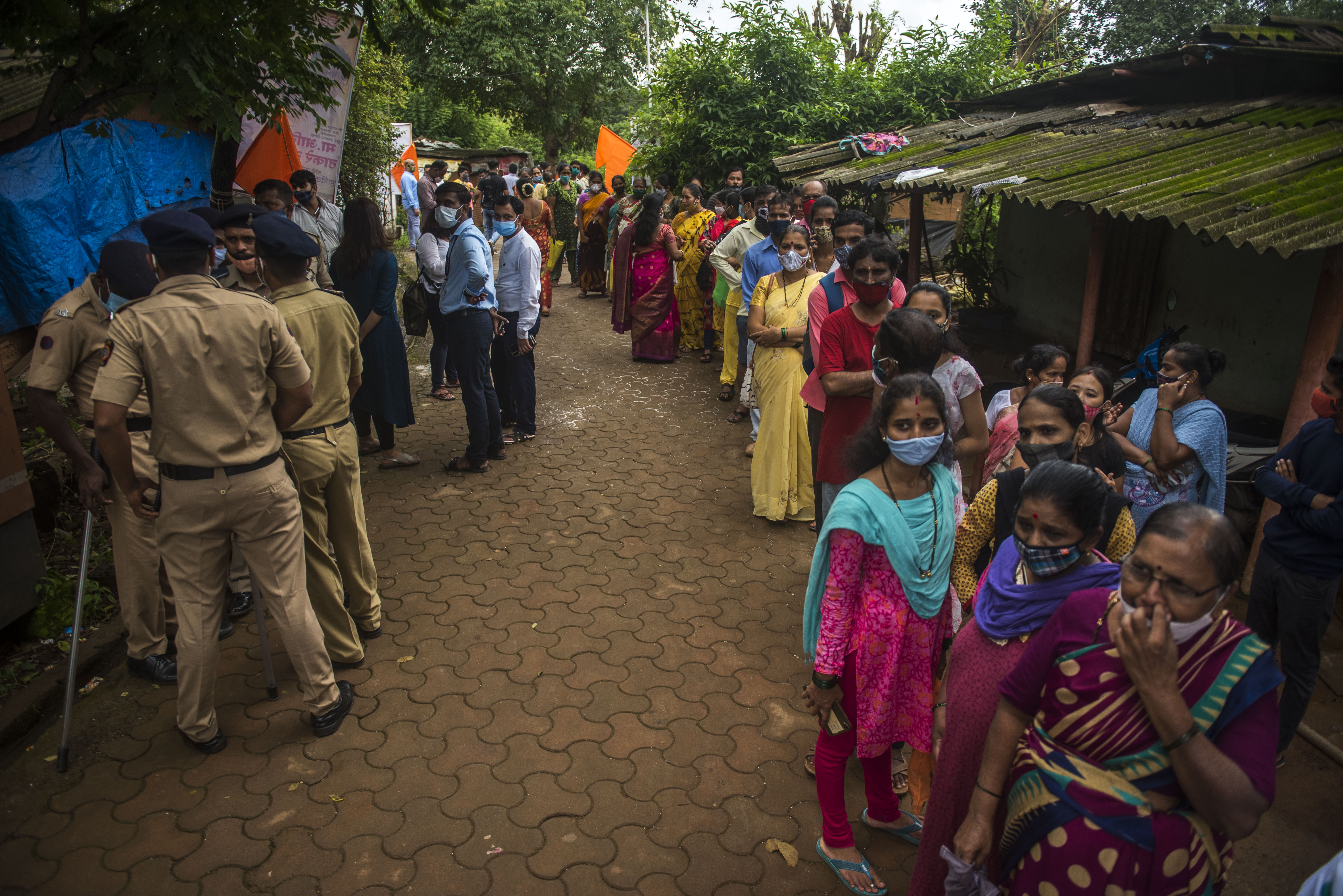 People stand in a line outside a vaccination clinic in India.