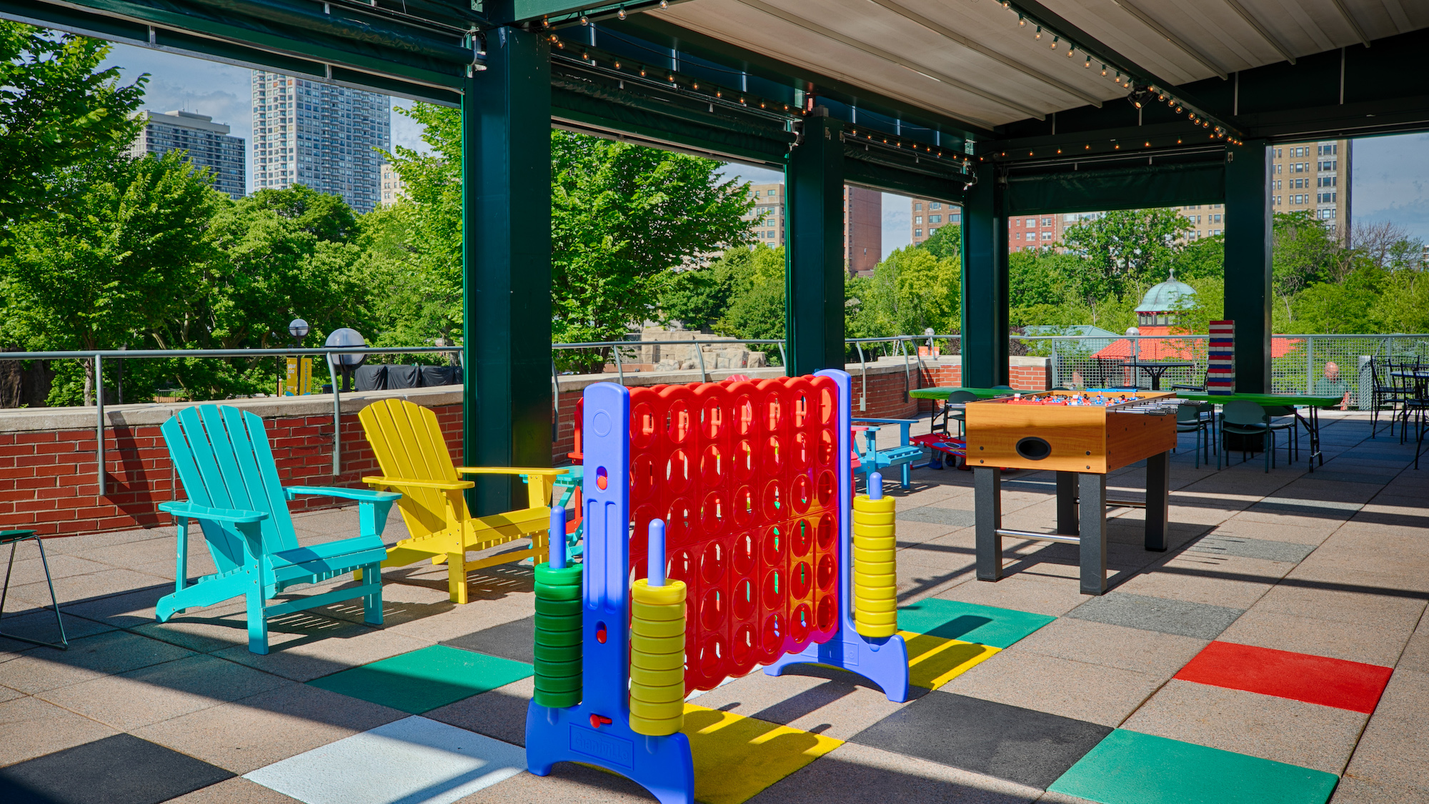 two Adirondack chairs, a giant Connect Four set, and a Foosball table