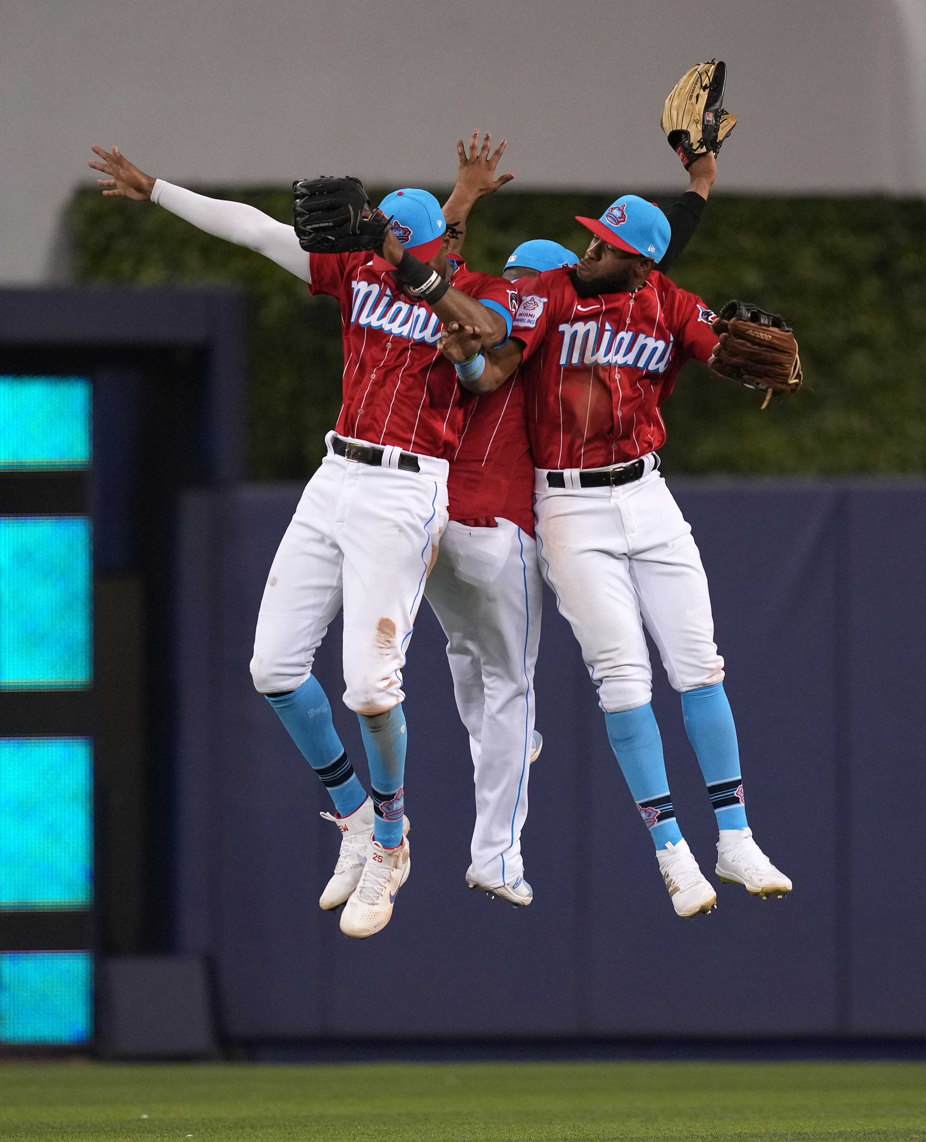 Miami Marlins center fielder Lewis Brinson (25), center fielder Magneuris Sierra (34) and right fielder Bryan De La Cruz (77) celebrate after defeating the Chicago Cubs at loanDepot park