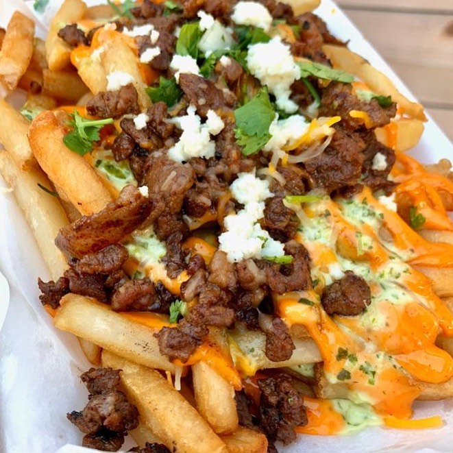 a plate of fries loaded with bulgogi, cheese and other toppings
