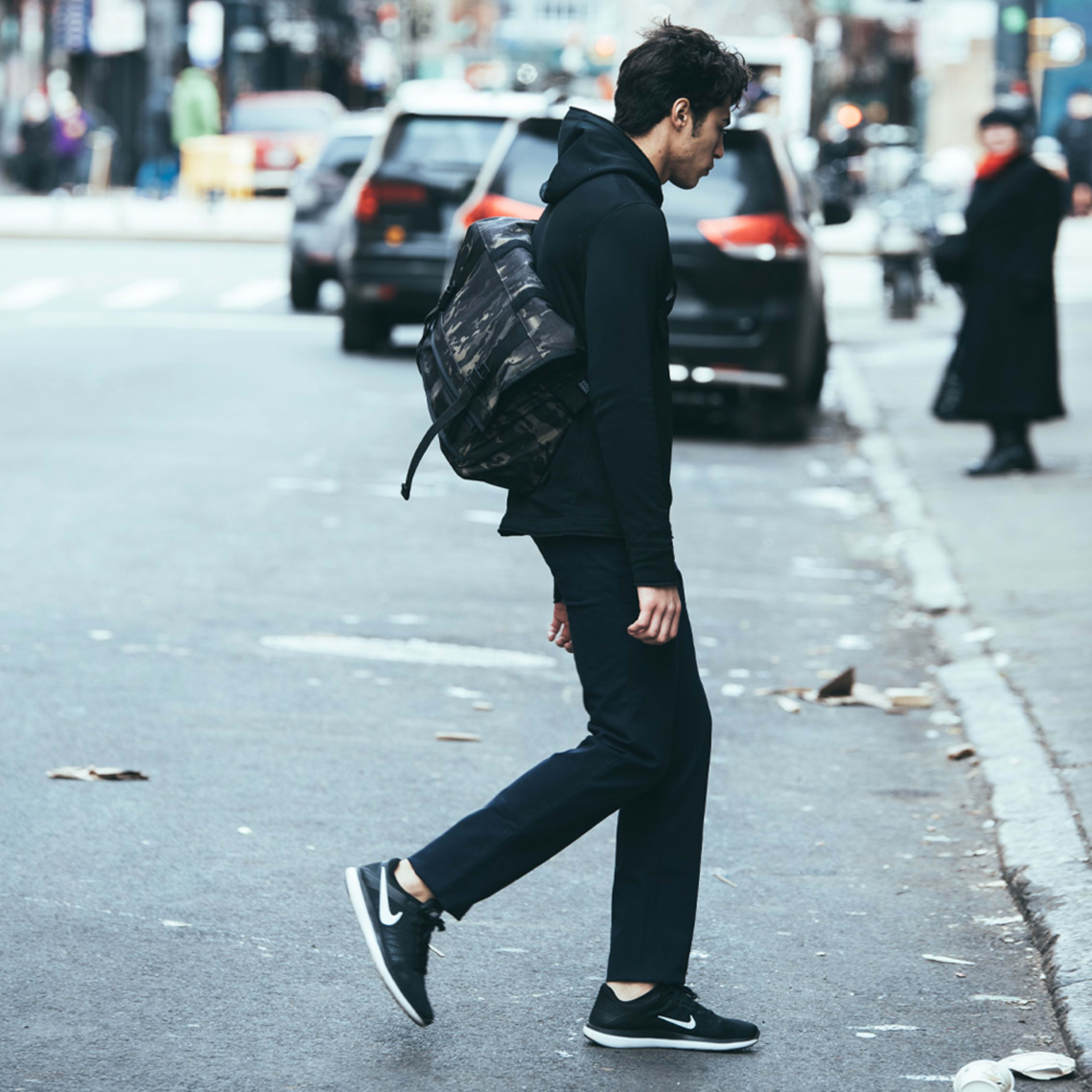 man crossing street with messenger bag