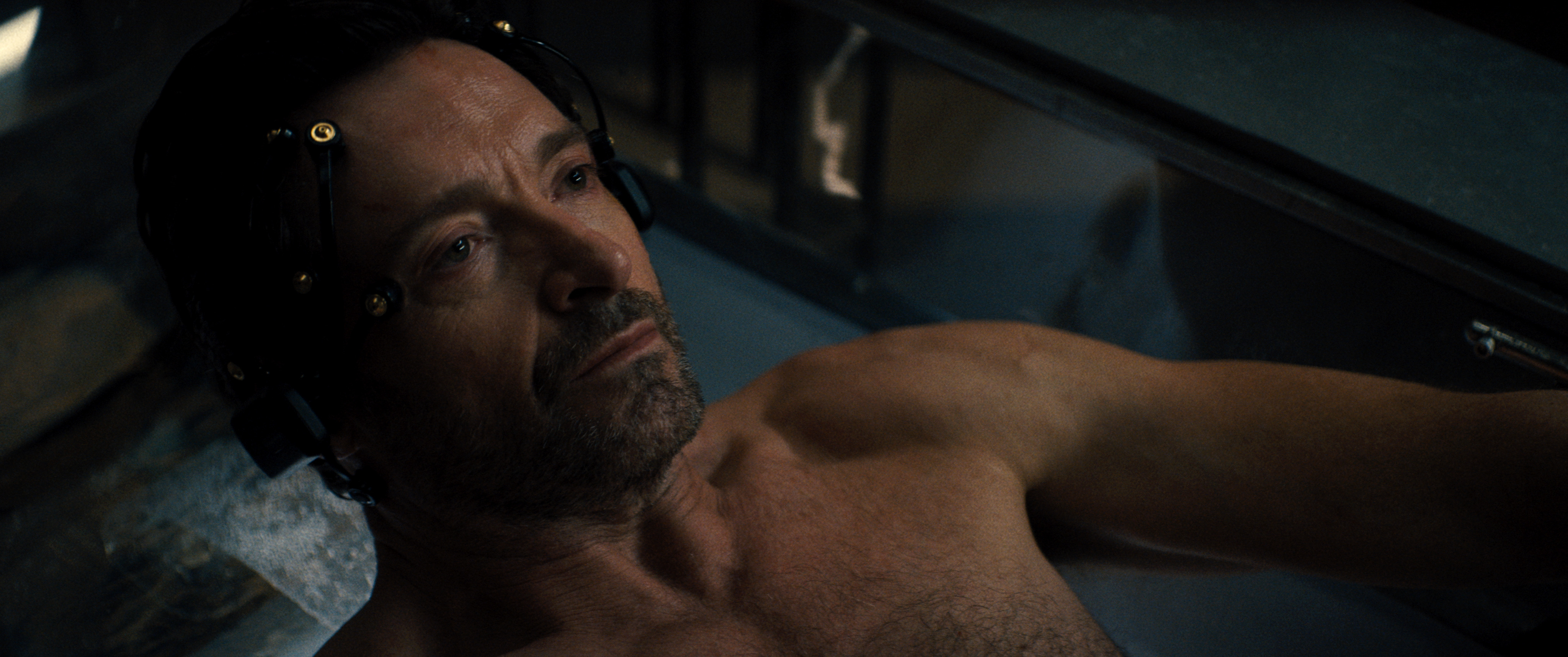 Hugh Jackman lies in a tank with electrodes on his head in the science fiction movie Reminiscence