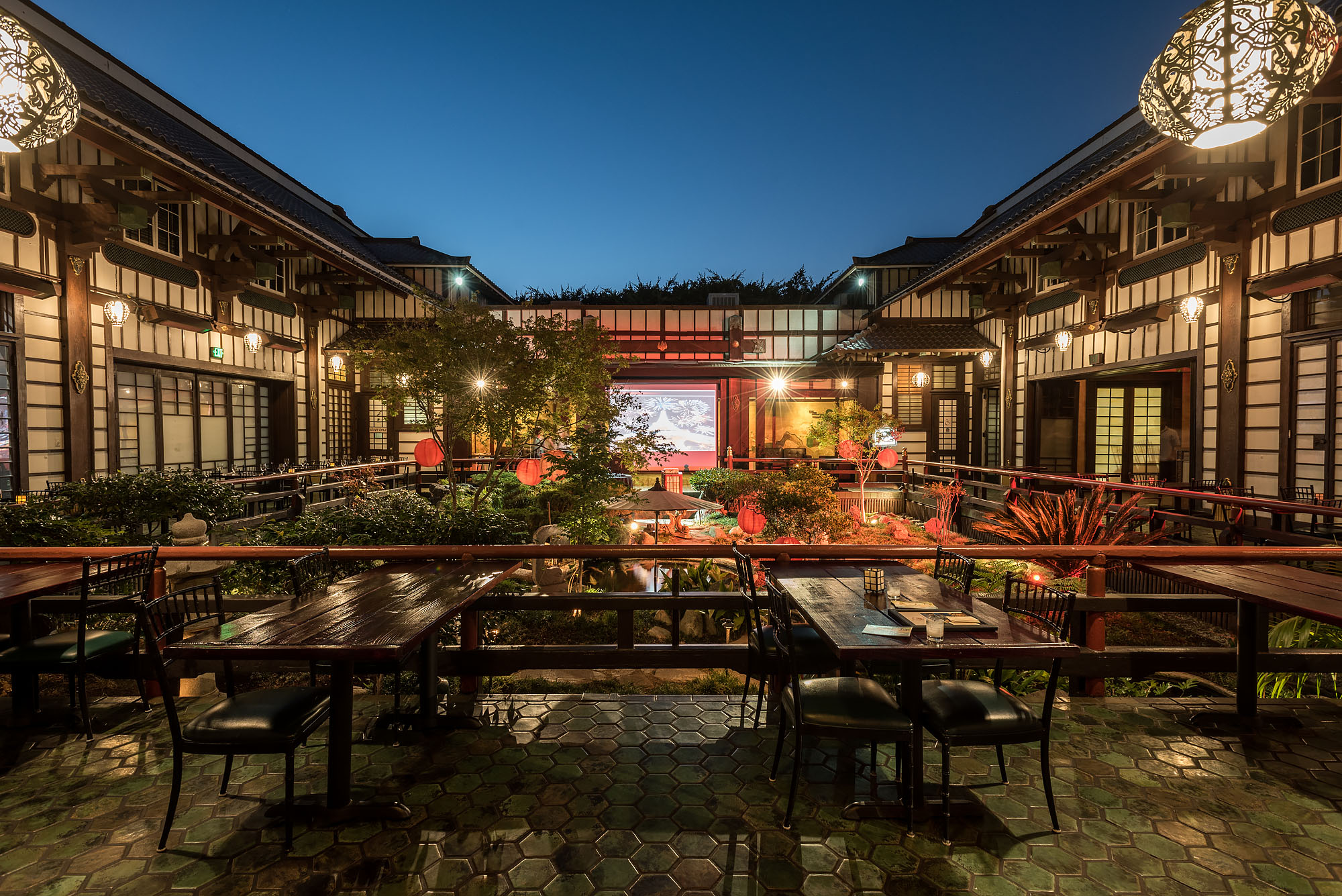 Yamashiro Hollywood’s inner courtyard with lots of wood and carvings and Asian art, shown at dusk.