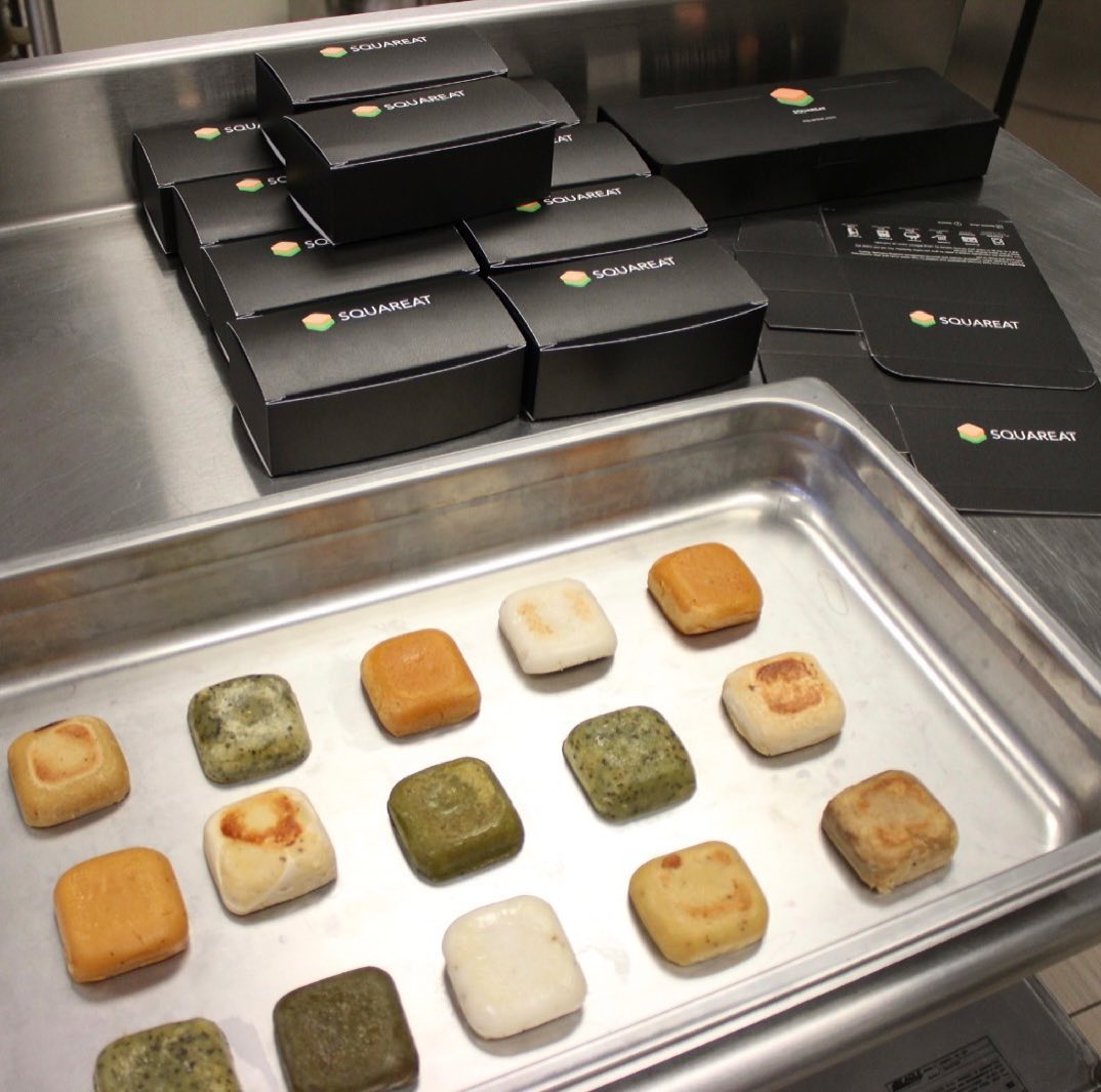 An overhead photo showing a metal sheet tray of square blocks of processed food.