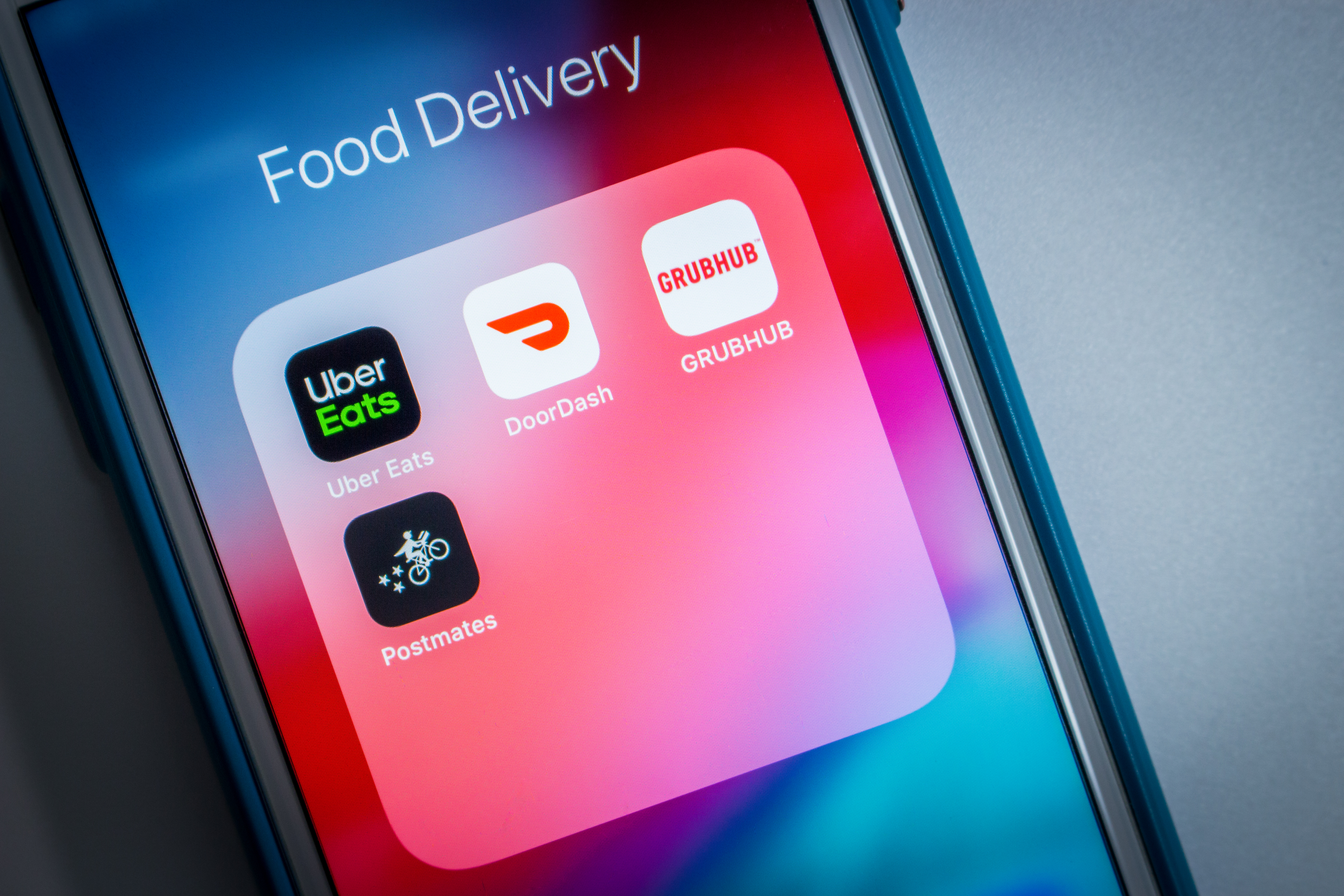 An iPhone folder screen loaded with four food delivery apps.