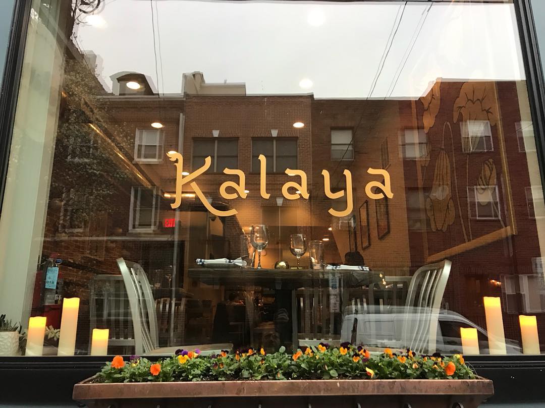 the front of kalaya thai kitchen restaurant with the word kalaya and candles on either side