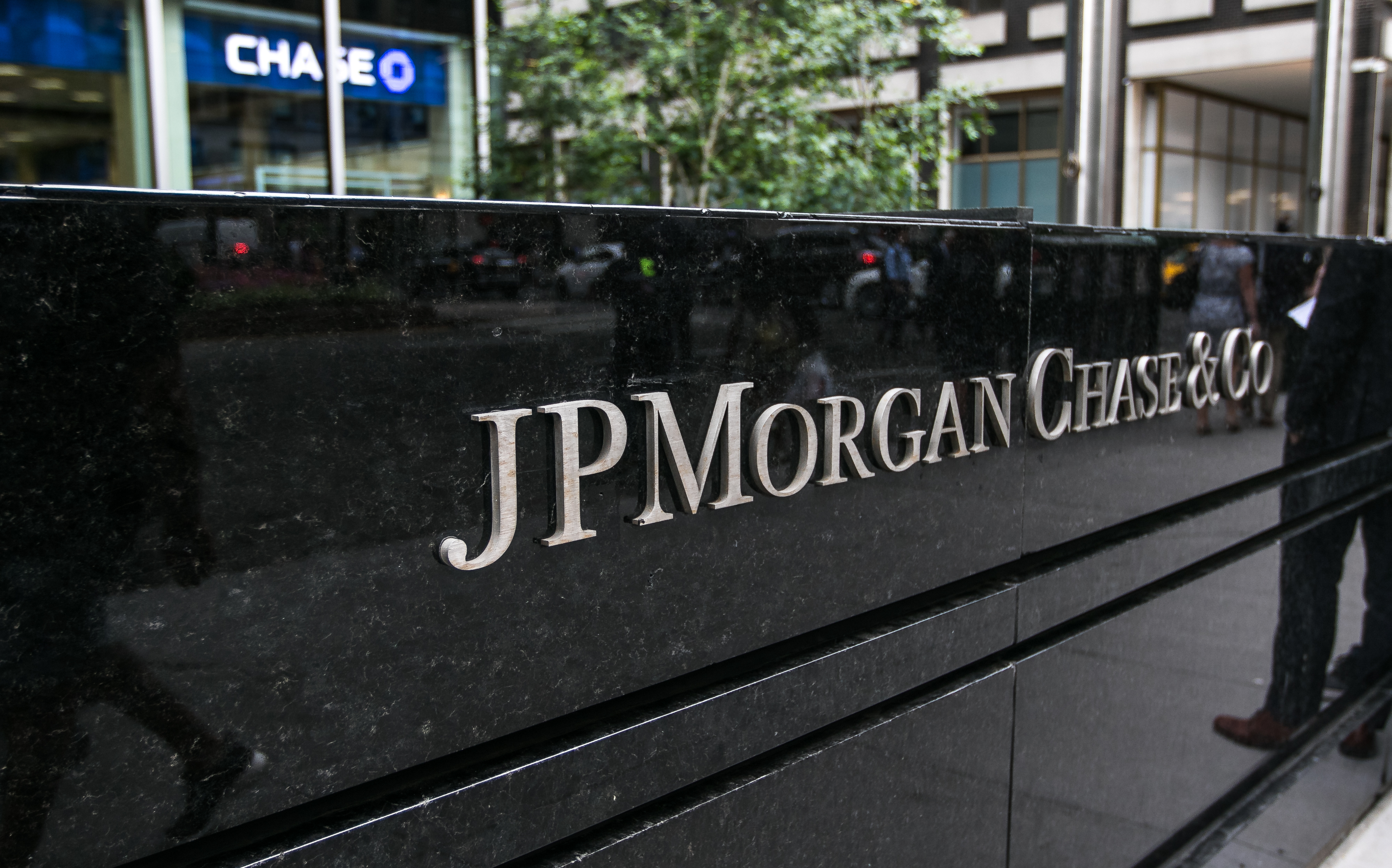 A black marble block sign reading “JP MORGAN CHASE &amp; CO” in silver letters outside of a Chase bank office building in Manhattan.