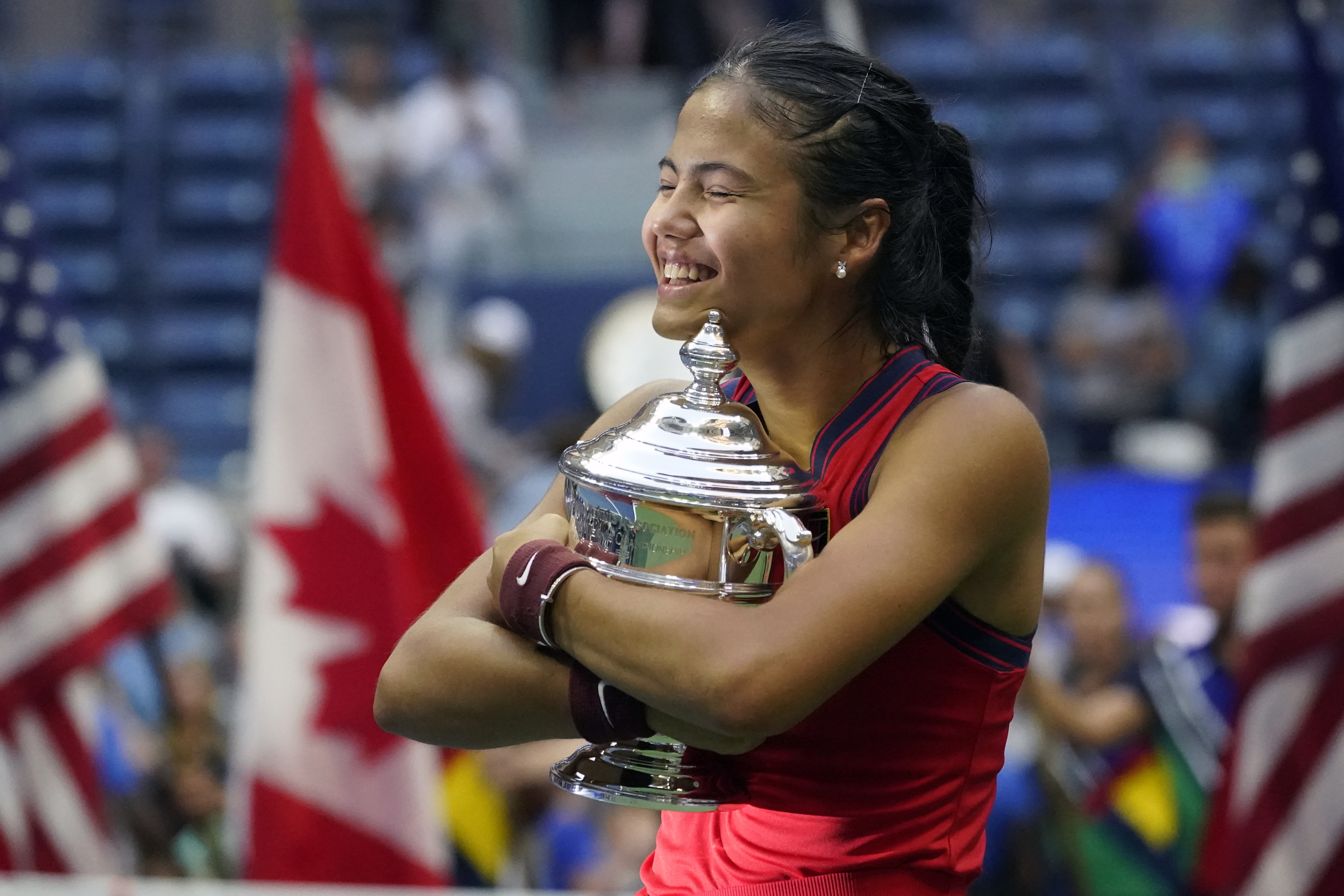 Emma Raducanu, of Britain, hugs the US Open championship trophy after defeating Leylah Fernandez, of Canada, in the women’s singles final.