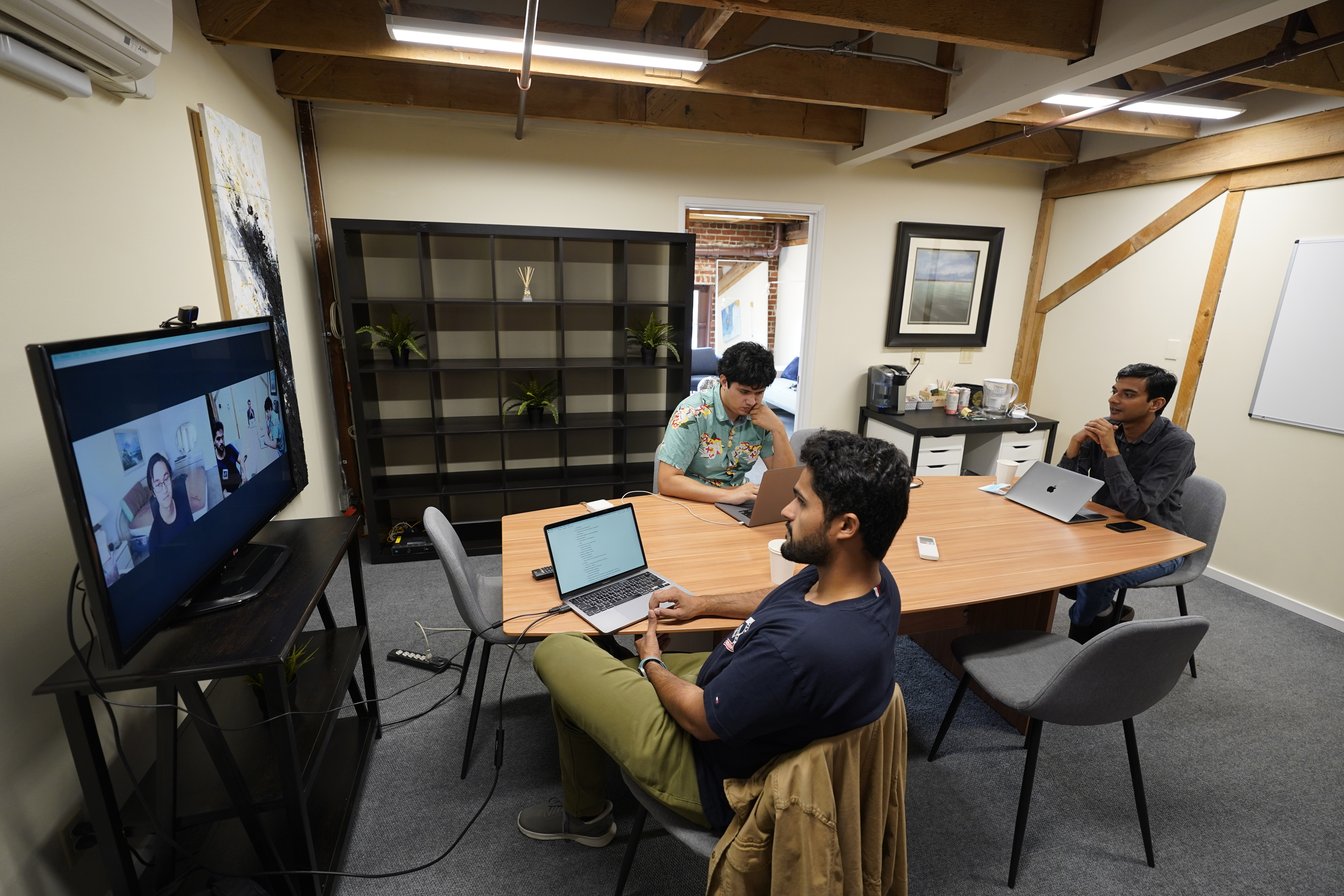 RunX CEO Ankur Dahiya (center) takes part in a video meeting with employees JD Palomino (left) and Nitin Aggarwal (right) at a rented office in San Francisco. Technology companies like RunX now face the challenge of how, when and even whether they should bring their long-isolated employees back to offices.