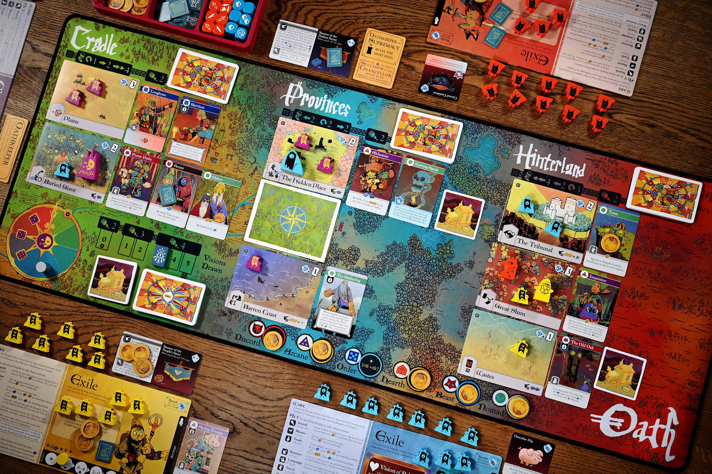 The base game of Oath laid out to play for six. The central game board is made of cloth, like a mousepad.