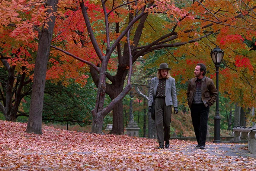 Meg Ryan and Billy Crystal walk through failed leaves on a fall tree-lined lane in the movie “When Harry Met Sally.”