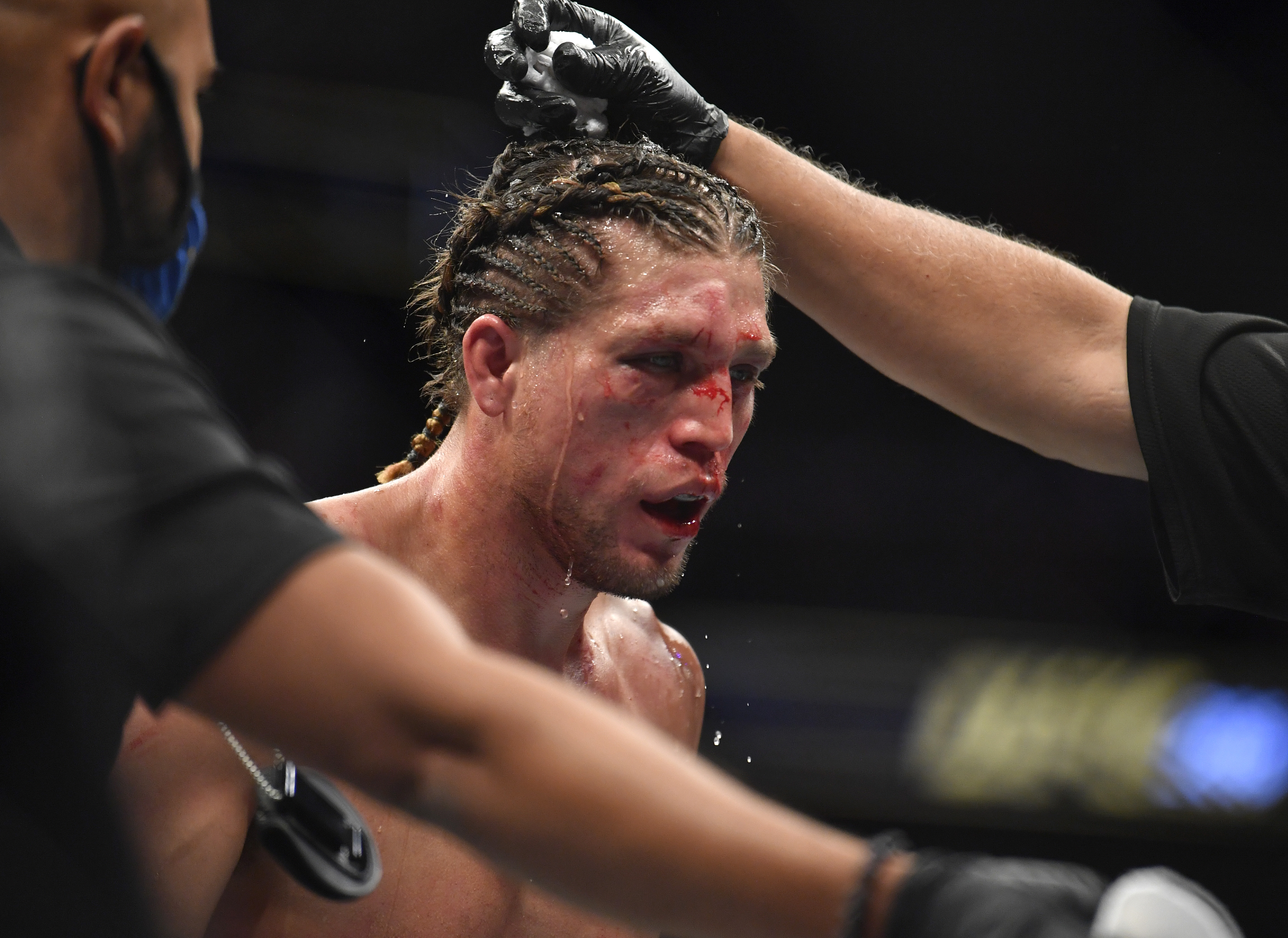 Brian Ortega being attended to during his fight with Alexander Volkanovski at UFC 266. 