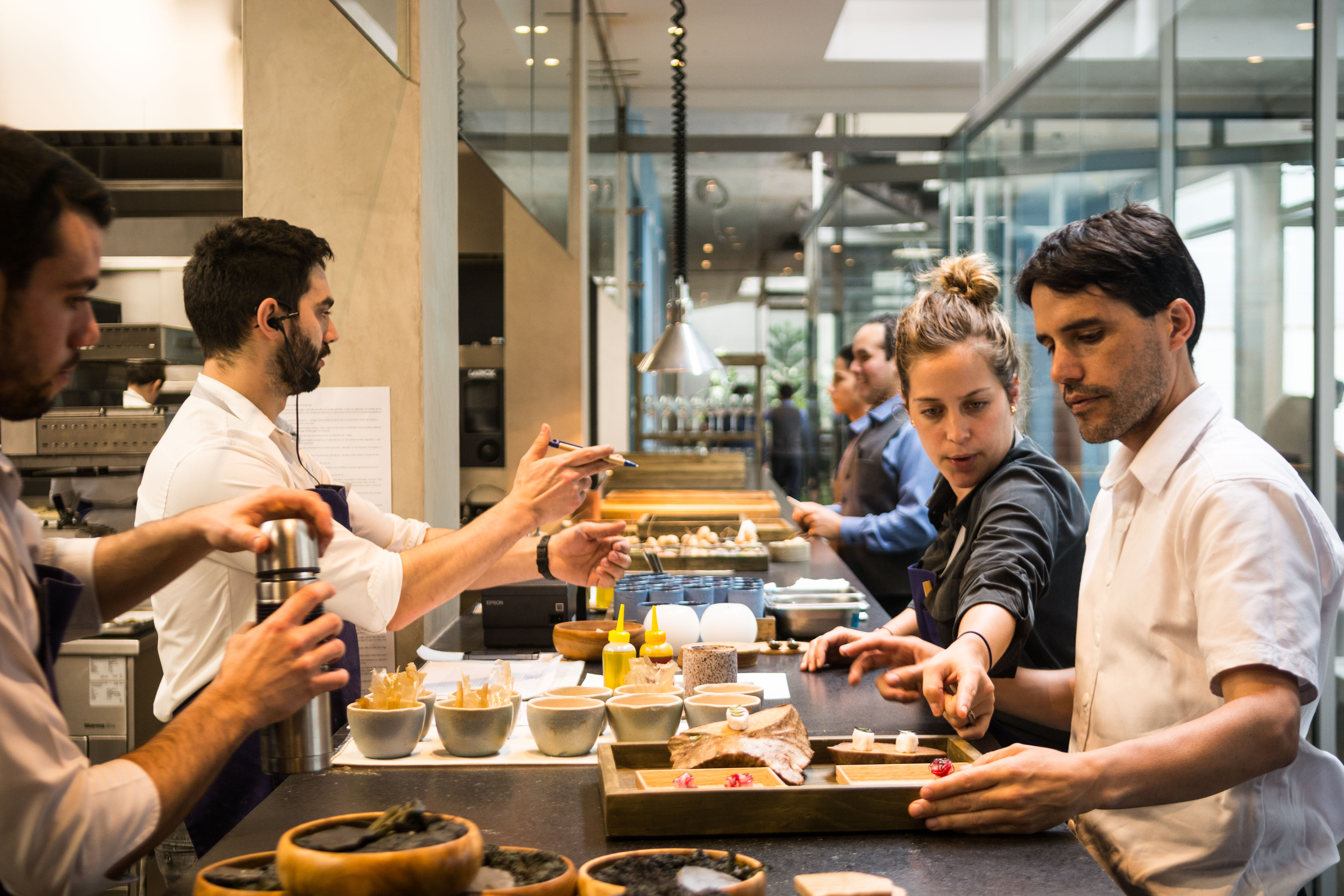 Chefs Pia León and Virgilio Martínez at the kitchen pass with other teammates at Central.