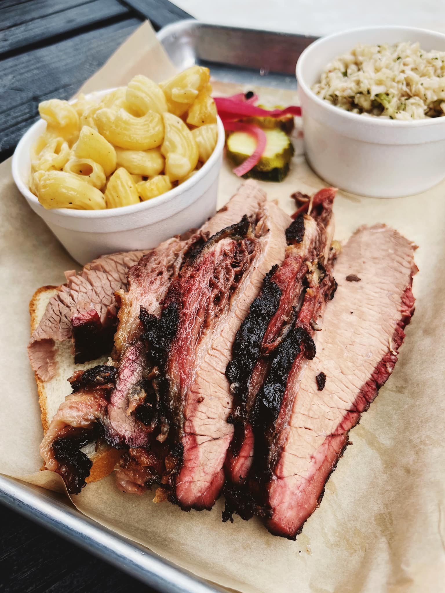 Slices of tender beef brisket paired with mac and cheese and coleslaw from Ford’s BBQ, now open in Tucker and Oakhurst-Decatur, Georgia. 