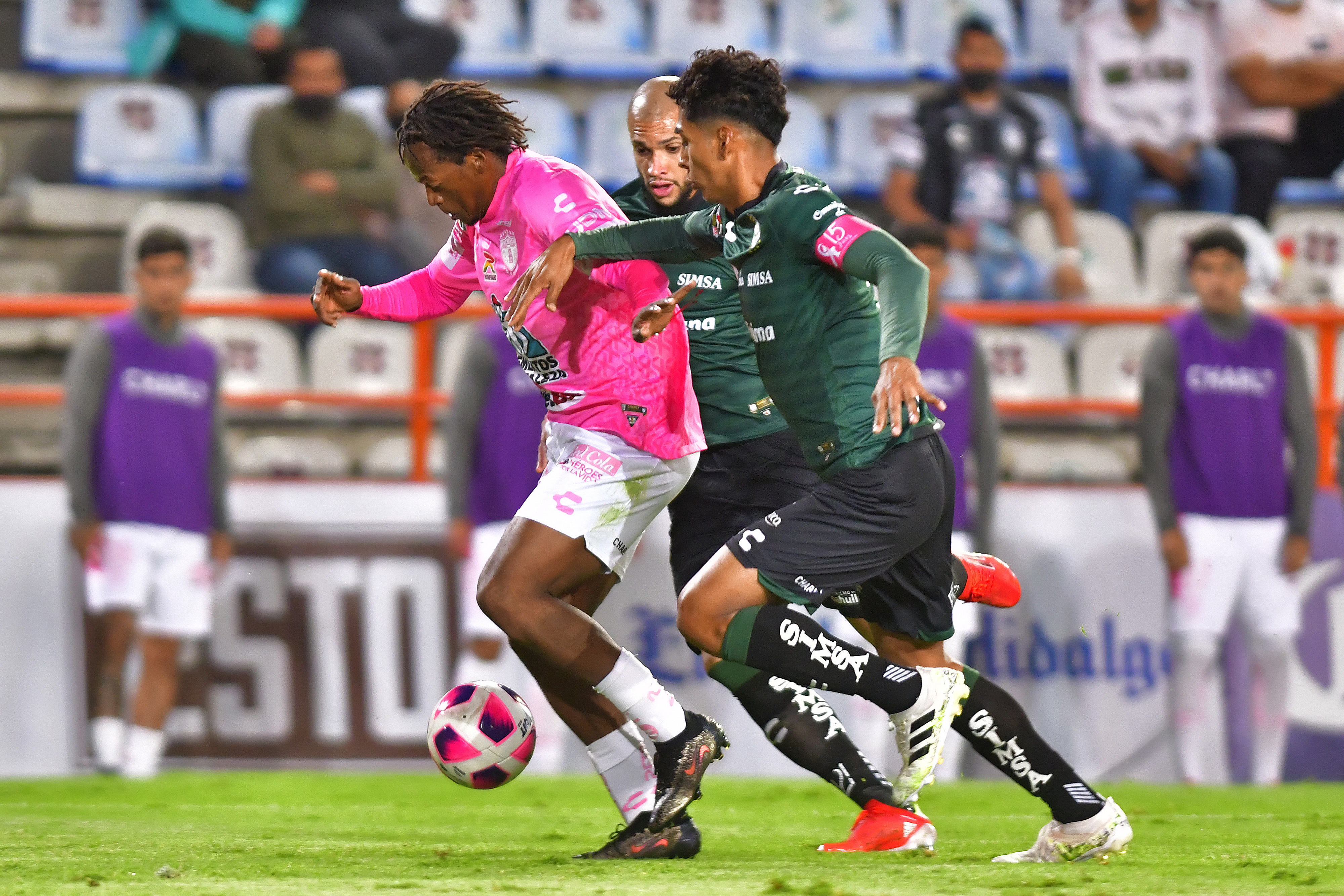 Romario Andres Ibarra (L) of Pachuca fights for the ball with Matheus Doria (C) and Hugo Isaac Rodriguez (R) of Santos during the 13th round match between Pachuca and Santos Laguna as part of the Torneo Grita Mexico A21 Liga MX at Hidalgo Stadium on October 16, 2021 in Pachuca, Mexico.