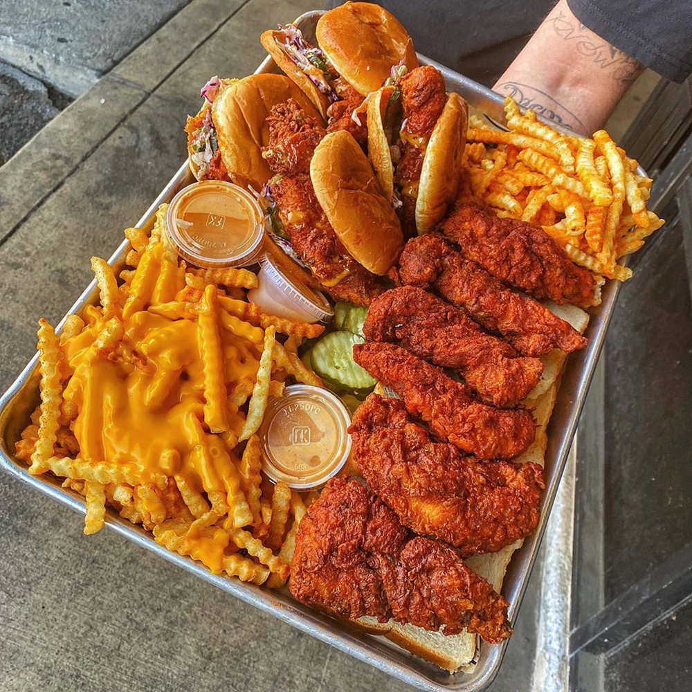 A tray of Nashville hot chicken sandwiches, tenders and cheese fries on the menu at Dave’s Hot Chicken.