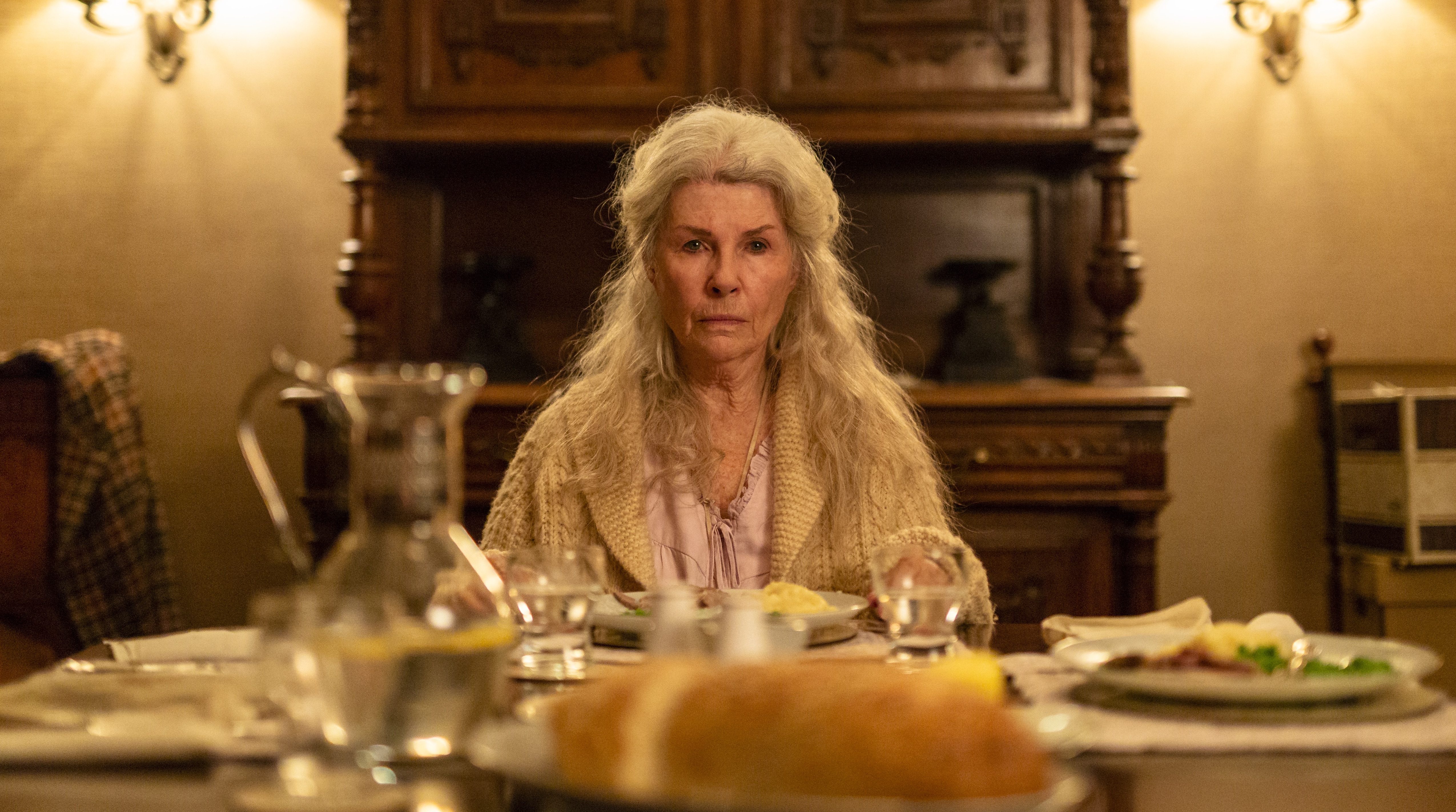 Robyn Nevin in Relic sits stone-faced at the dinner table, surrounded by untouched food.